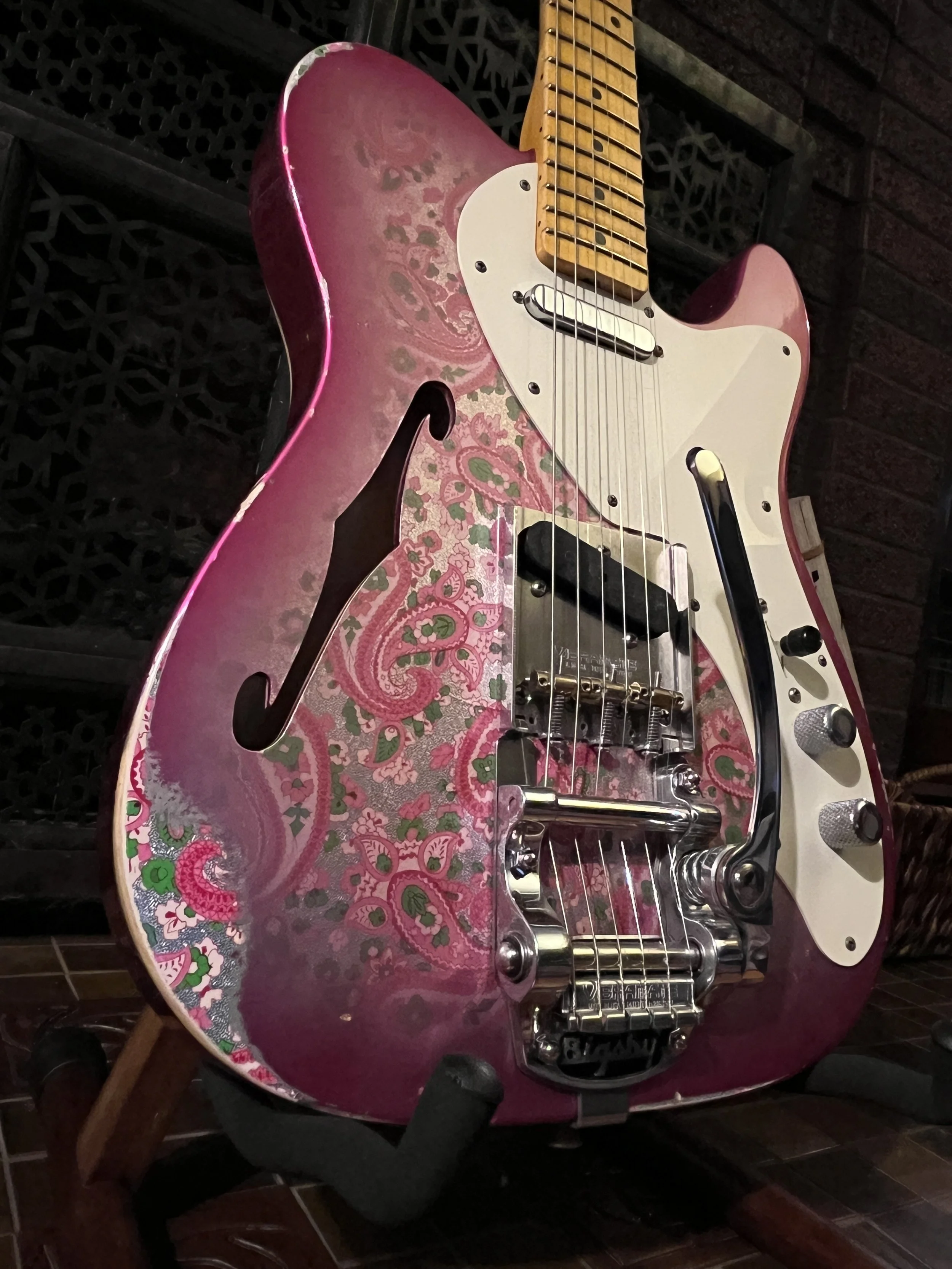 The front of the body of a reliced pink paisley Fender Telecaster Thinline 50s with Bigsby.