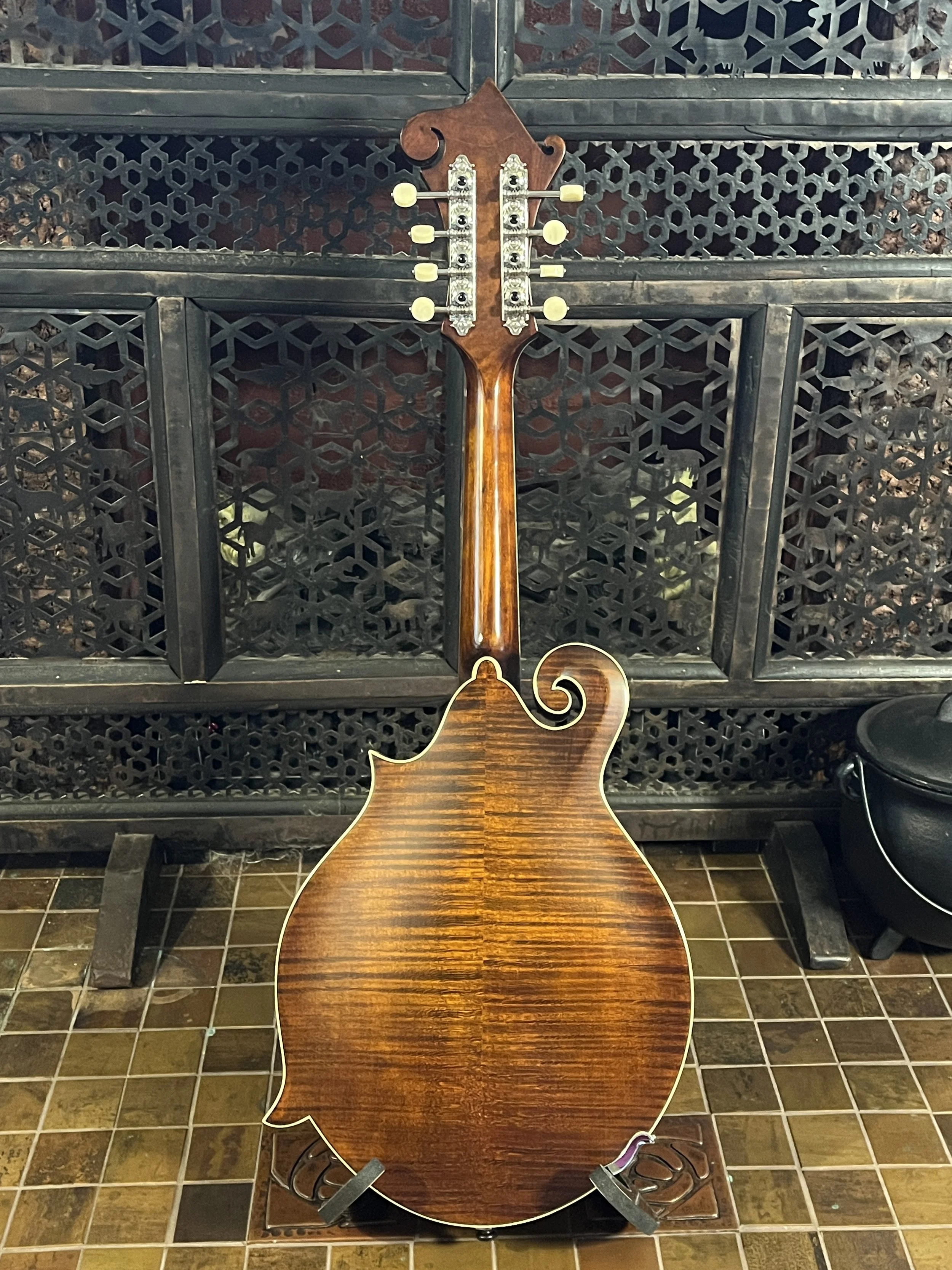 Eastman 715 Mandolin sitting on a stand, back-side shown, including maple back, neck, and tuners.(2024, #6 of 15, original run)