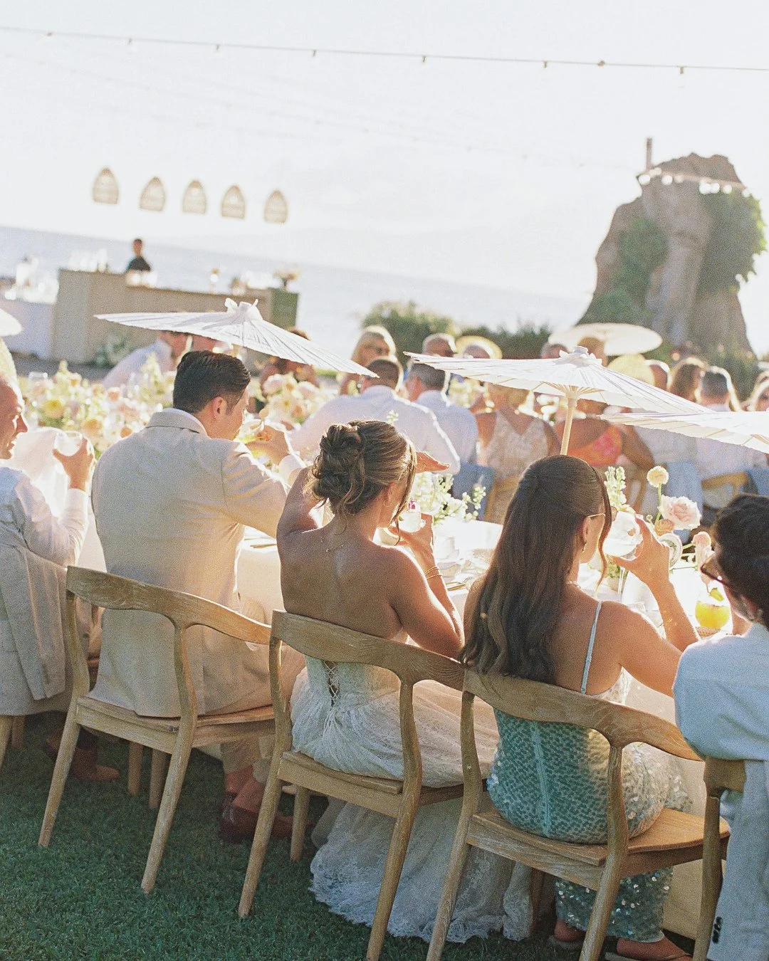 Shady and chic ☀️🤍 A moment for the white parasols keeping guests cool in style.⁠
⁠
Planning: @opihilove⁠
Photography: @dmitriandsandra⁠
Content Creator: @mauisocialmedia_bts⁠
HMU: @ameliahairandmakeup @lokahicollective⁠
Flowers: @bellabloommaui⁠
Ba