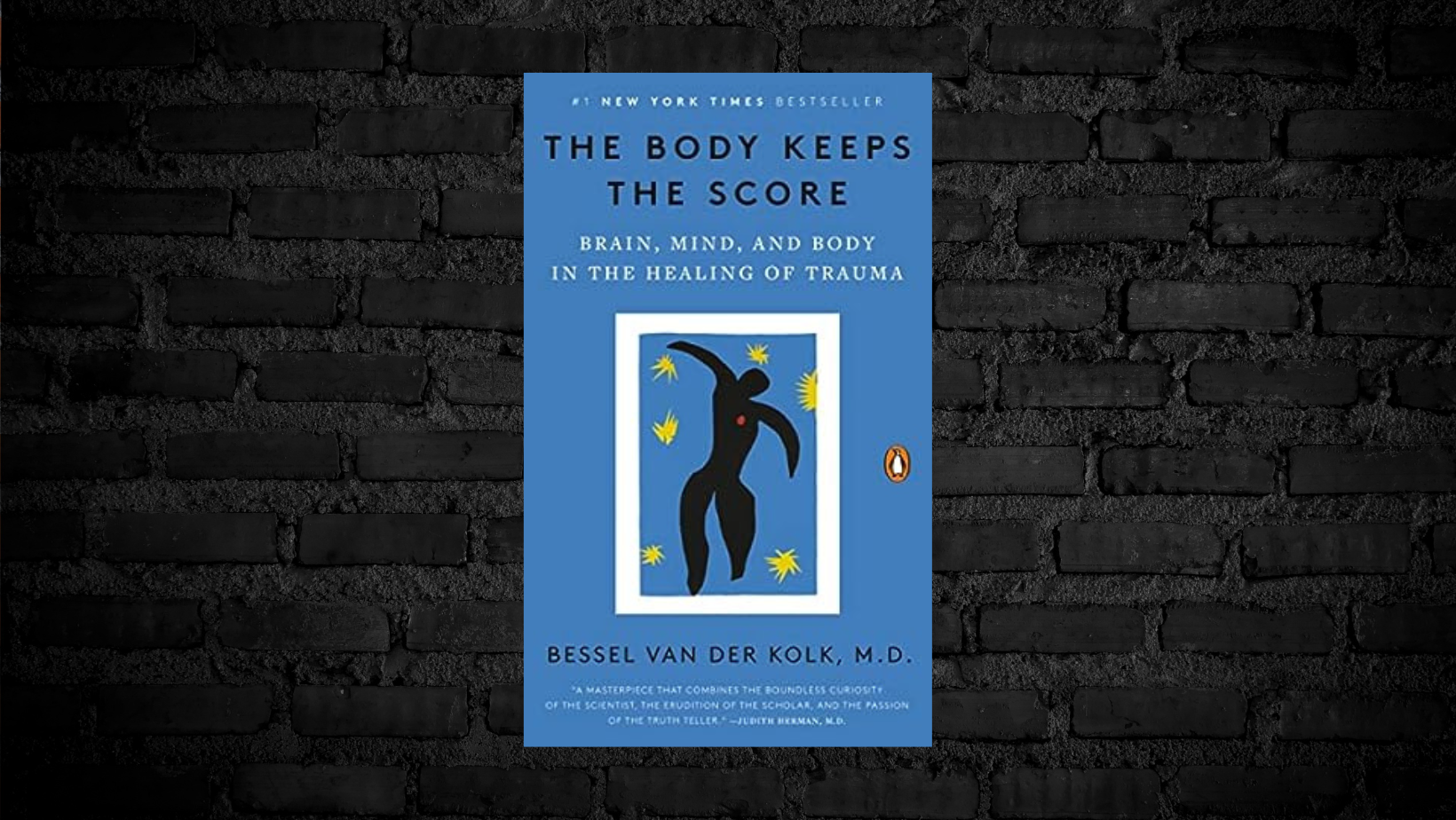 Book cover titled 'The Body Keeps the Score' by Bessel van der Kolk, M.D., with a blue background and abstract black figure with yellow stars surrounding it, set against a dark brick wall.