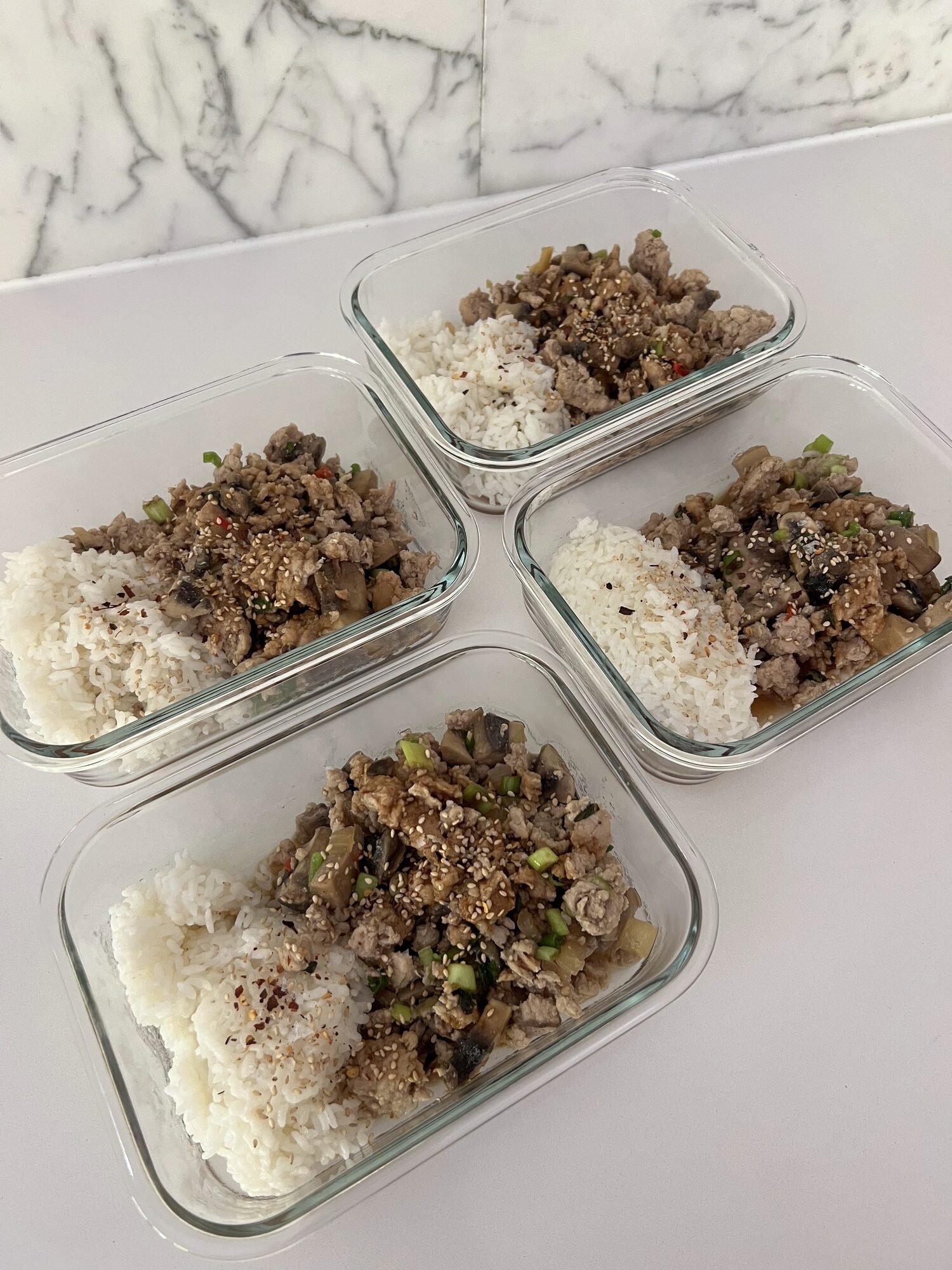 Rice bowls portioned into glass containers for weekly meal prep