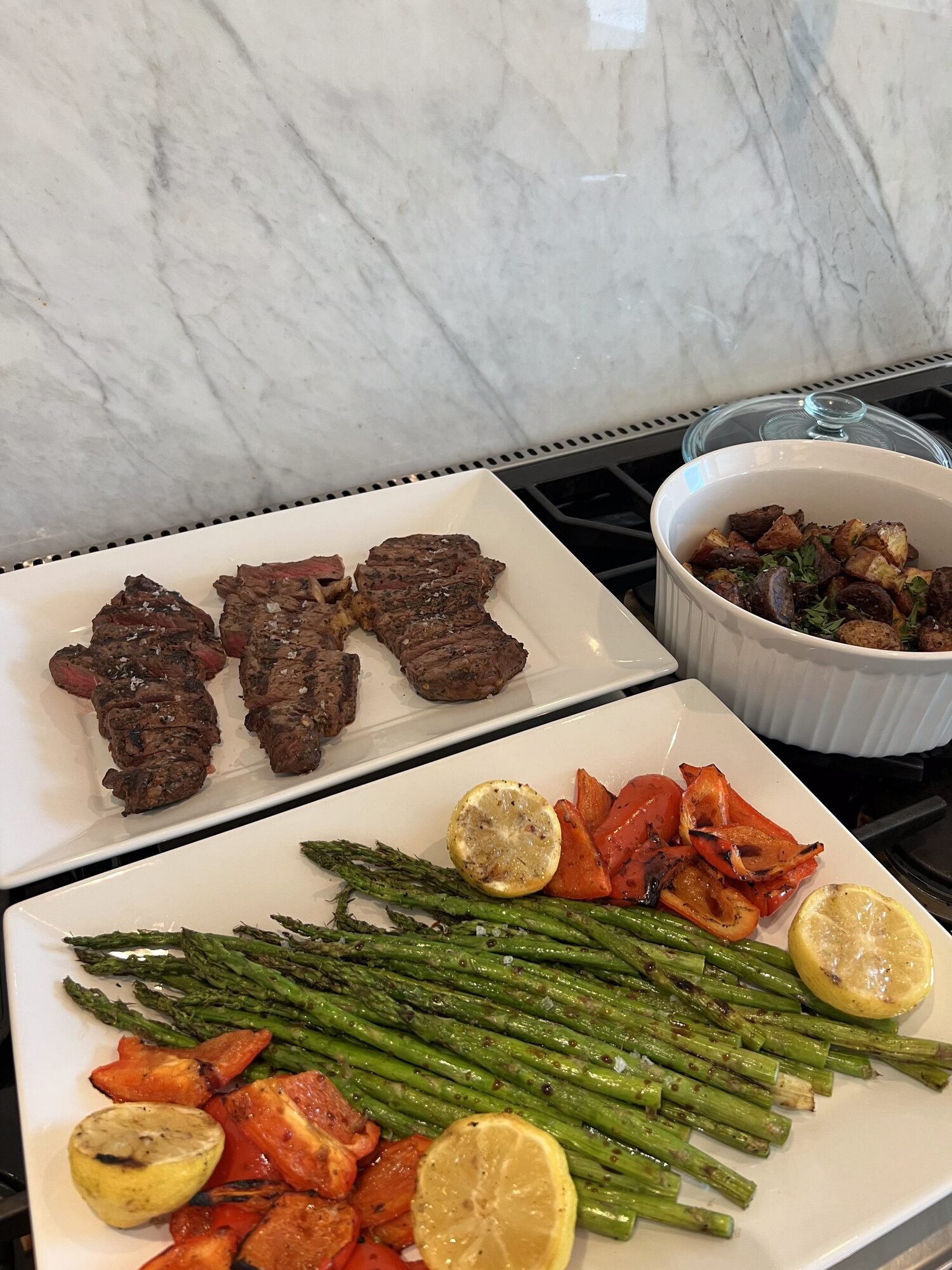 Sliced steak with roasted asparagus and peppers, a private chef dinner