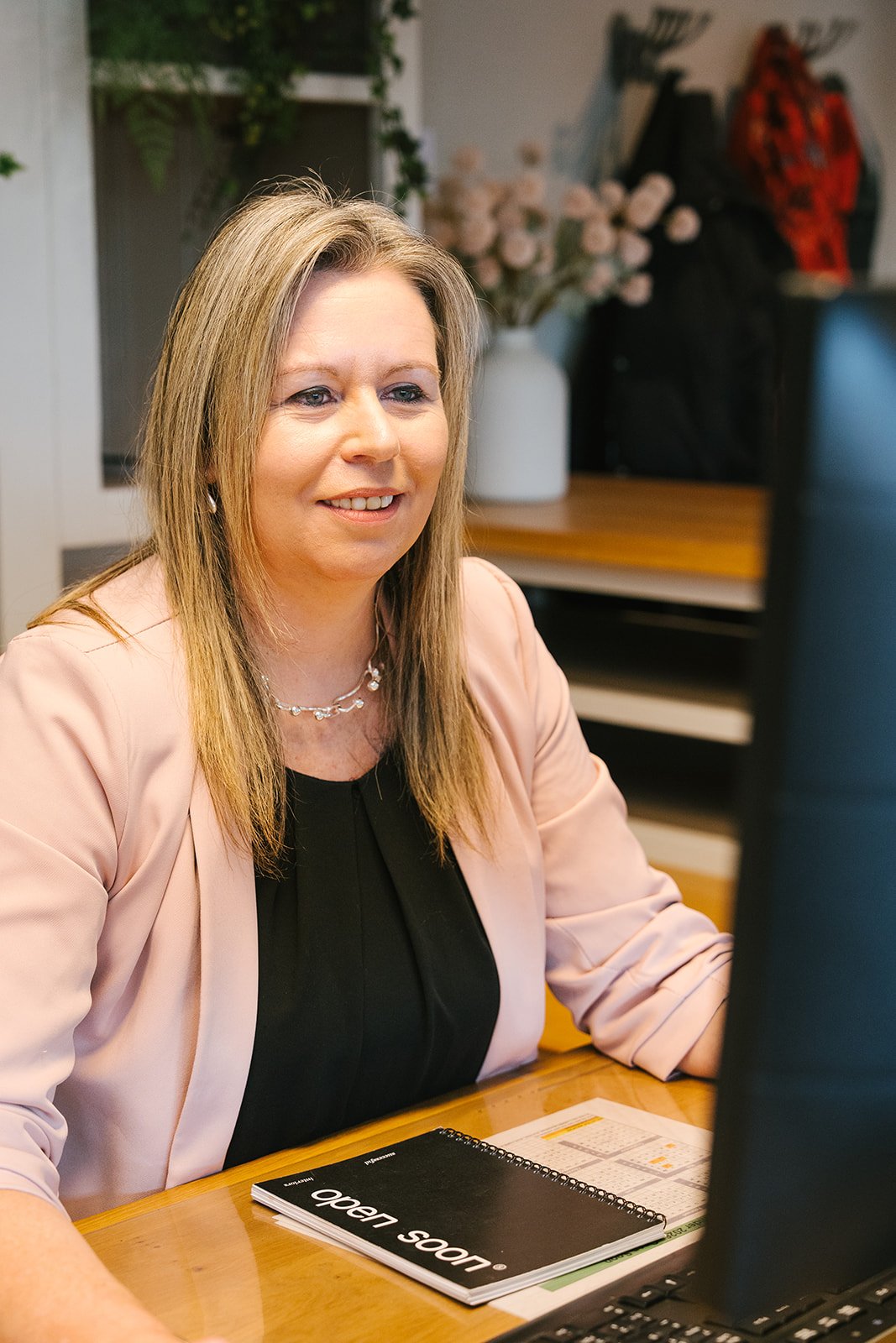 Portret van een vrouw met bruin haar, gekleed in een zwart jasje.