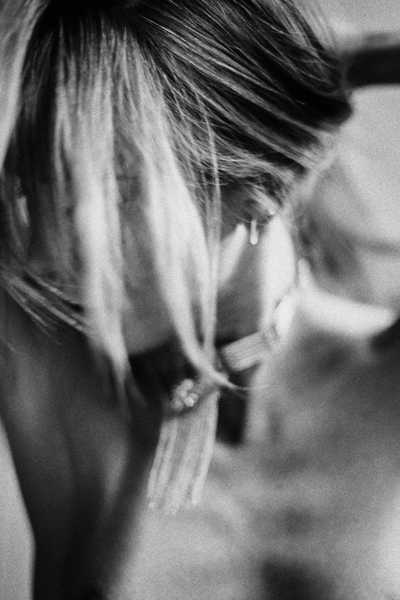 highly abstract black-and-white close-up of neckline and statement necklace with soft motion blur.