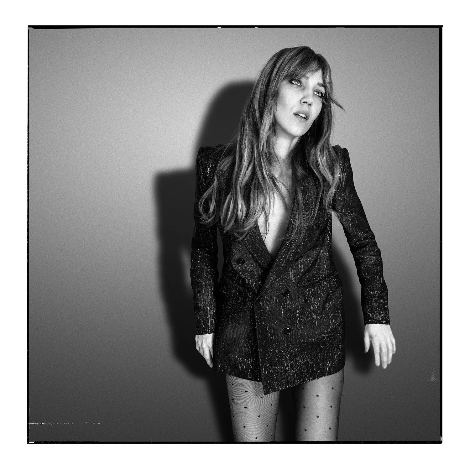 Editorial black and white portrait framed with an analogue aesthetic, evoking classic rock-and-roll photography and ritual symbolism.