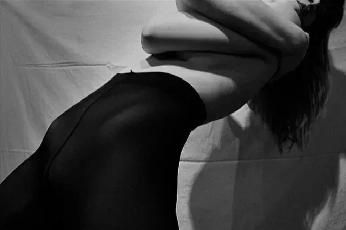 Black and white self-portrait emphasizing elongated body lines and shadow, focusing on form, movement, and physical expression.