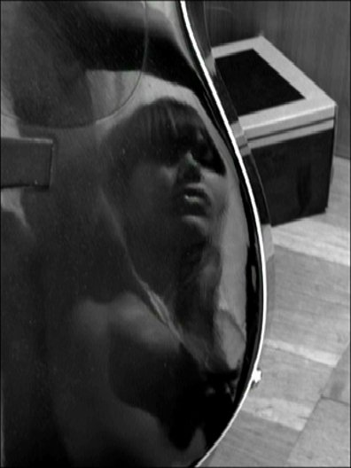 self-portrait of a woman in the reflection of a guitar