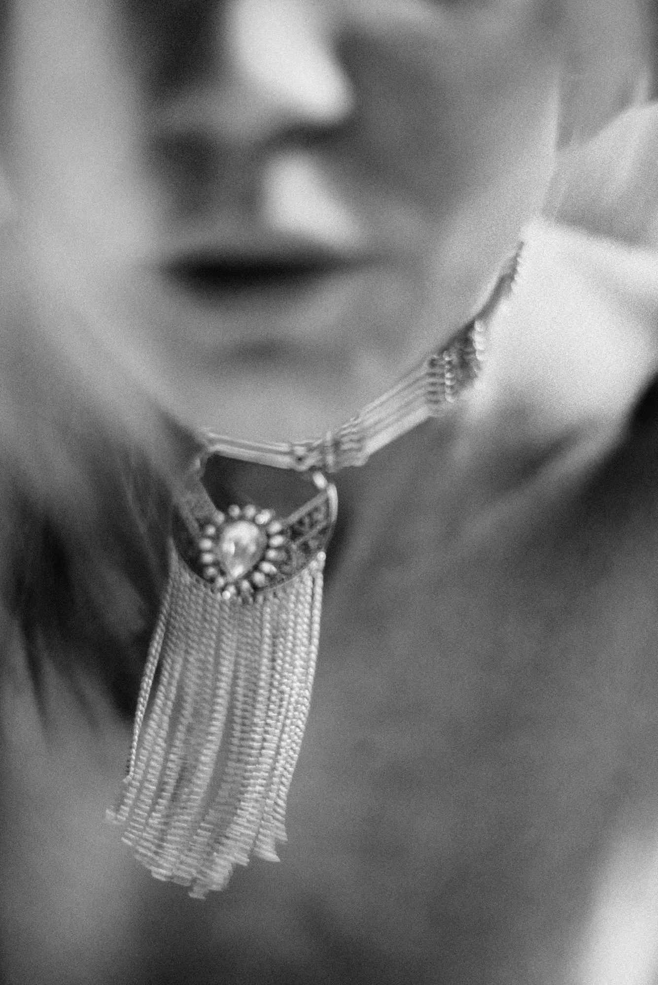 Minimal black-and-white portrait fragment showing jawline and neck in shallow focus.