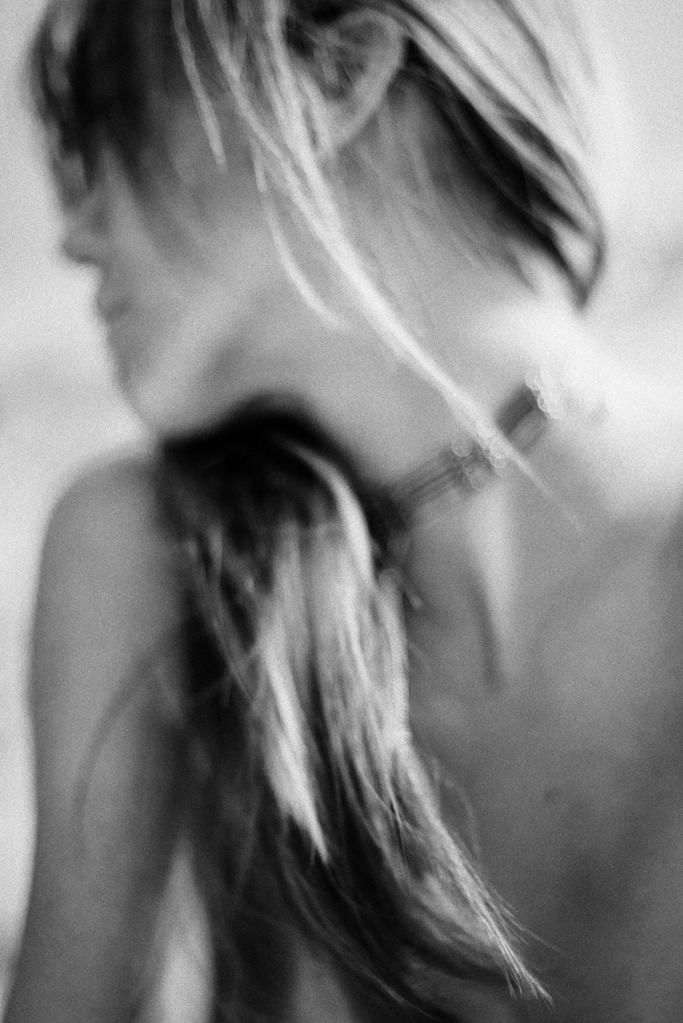 Minimal black-and-white portrait fragment showing jawline and neck in shallow focus.