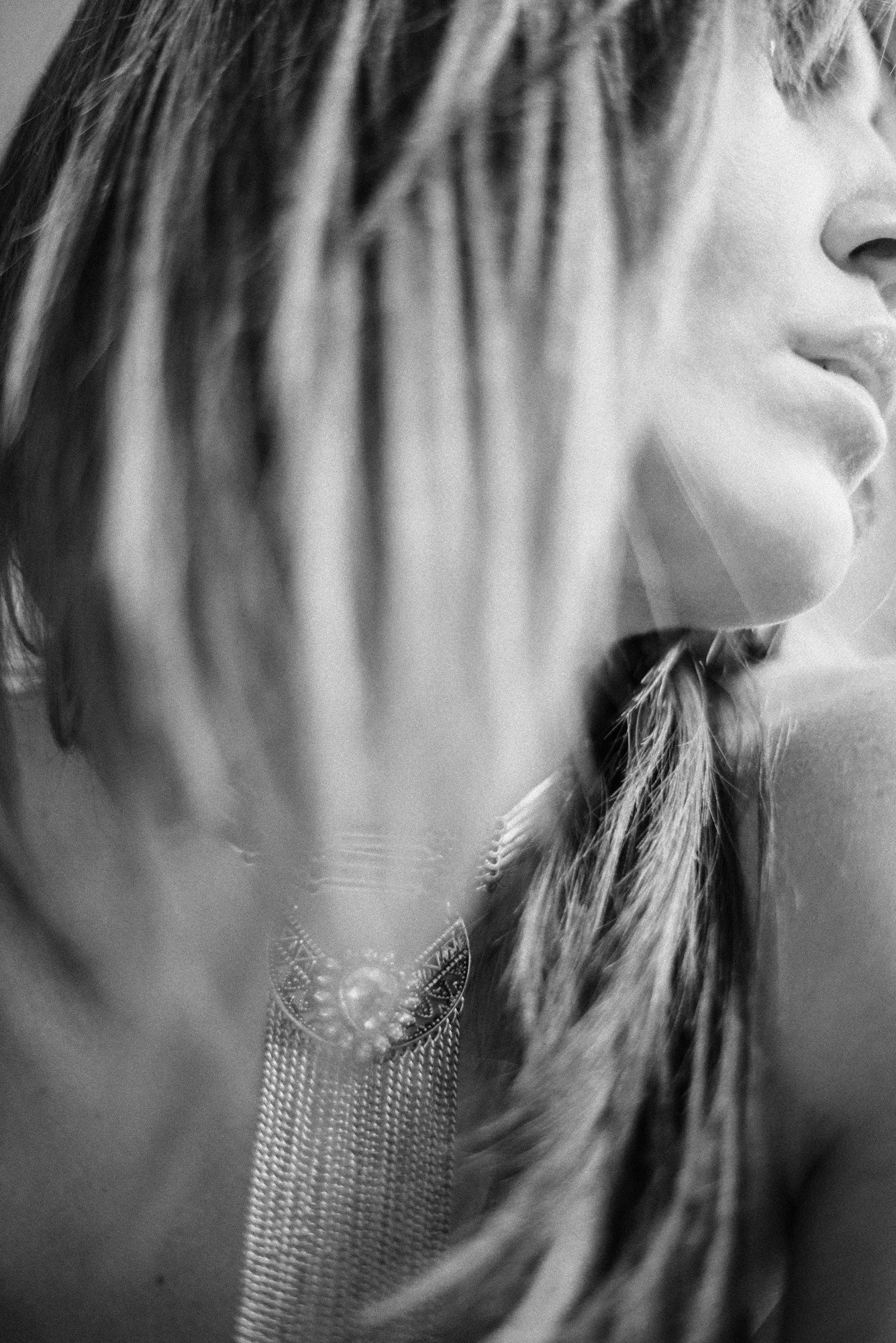 highly abstract black-and-white close-up of neckline and statement necklace with soft motion blur.