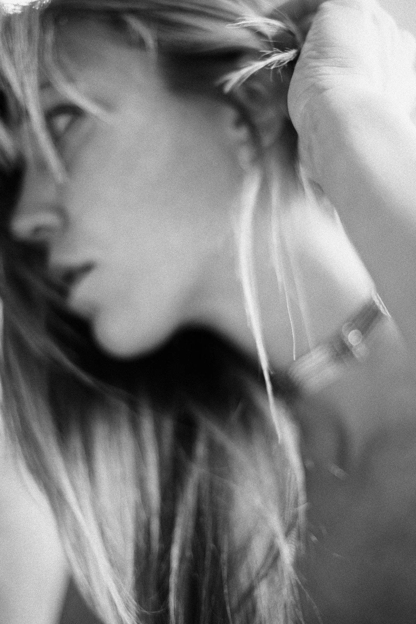 Minimal black-and-white portrait fragment showing jawline and neck in shallow focus.