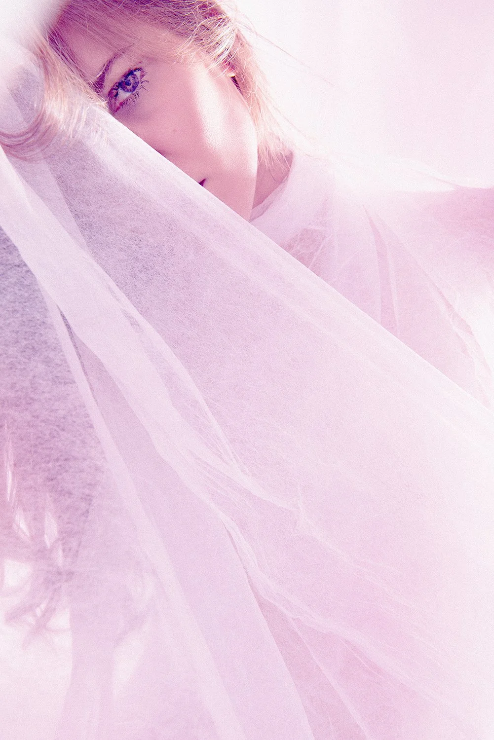 Close-up self-portrait partially veiled in translucent fabric, revealing vulnerability, presence, and inner calm