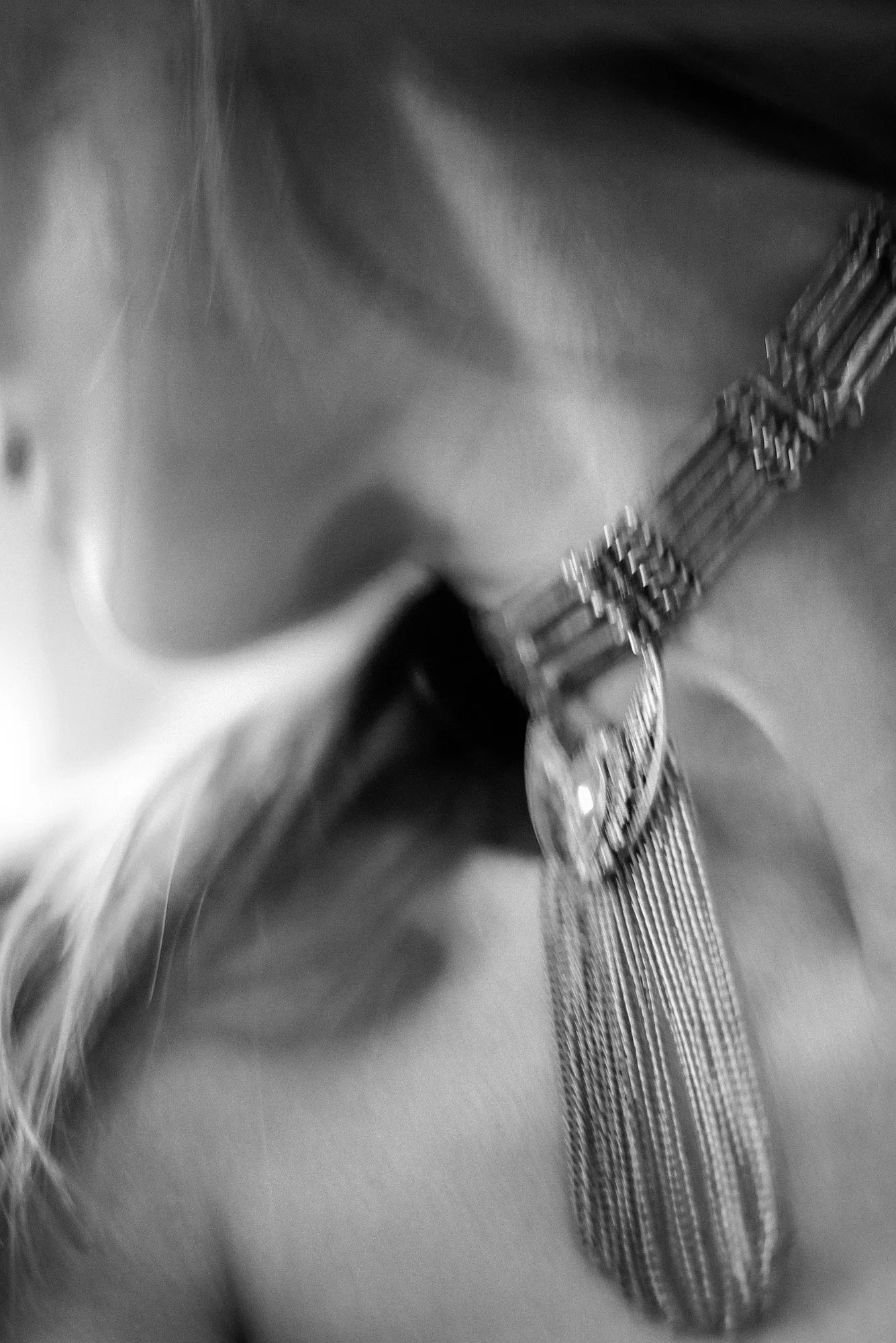 Minimal black-and-white portrait fragment showing jawline and neck in shallow focus.