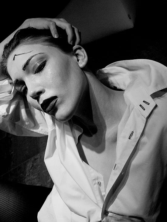 ashes to ashes inspired self-portrait of a woman in a dramatic pose, holding her head, stark contrasts