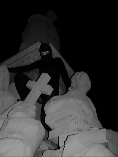 low exposure image of a dark silhouette photographed from below standing behind a sculpture