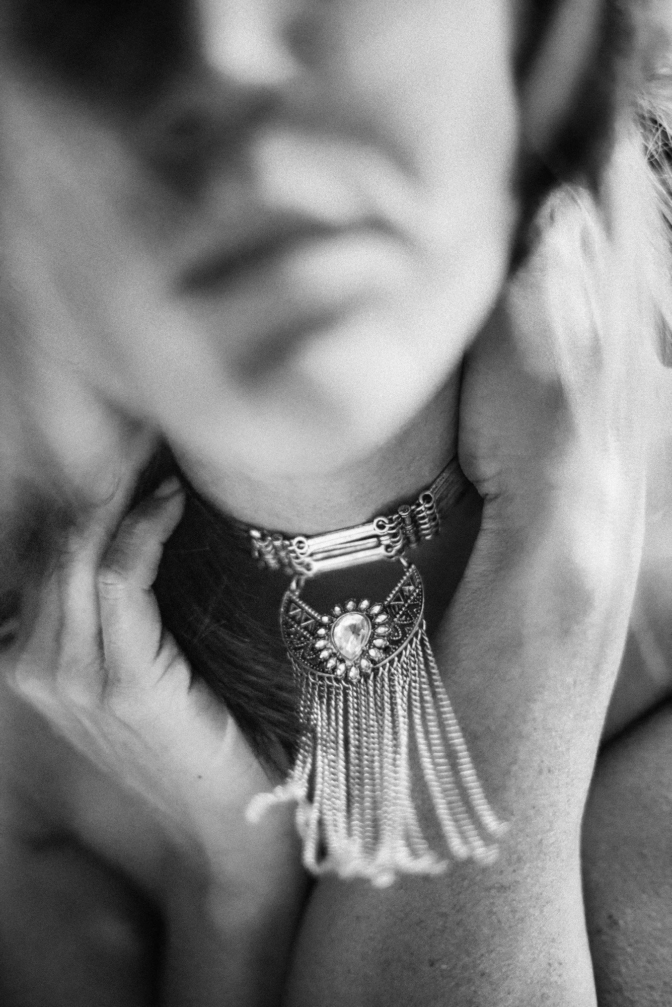 Abstract black-and-white portrait with hand touching neck, captured in soft motion blur.