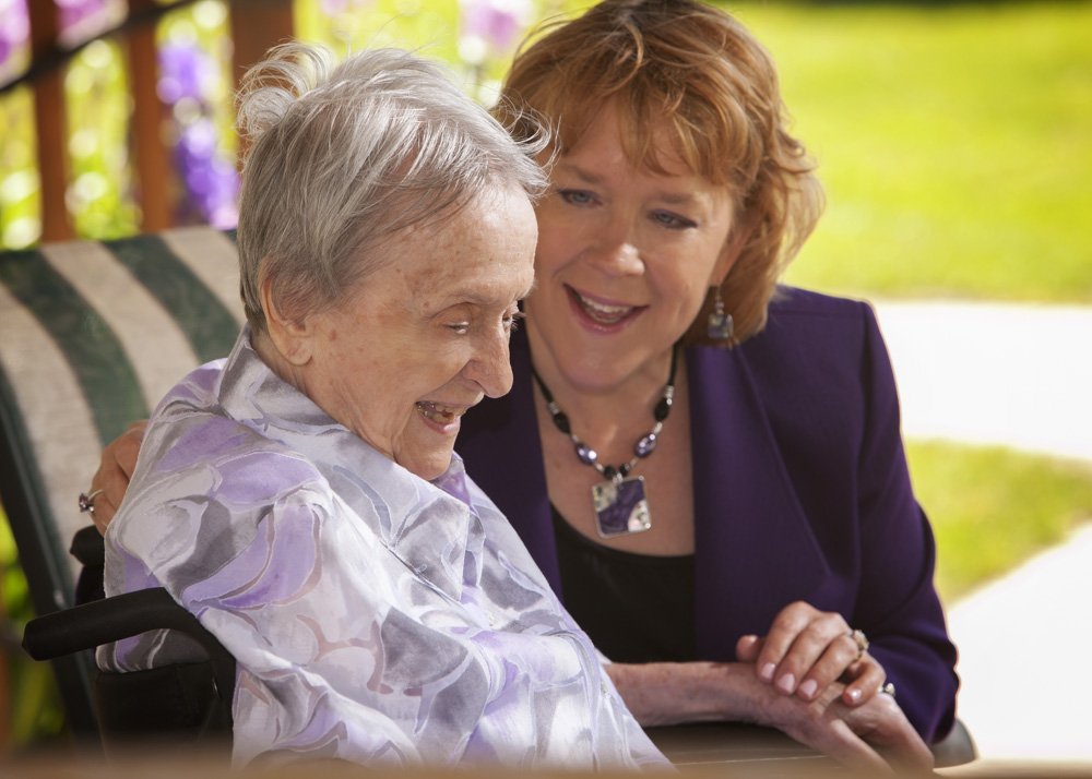 Carol Wessels holding hands with her elderly monther