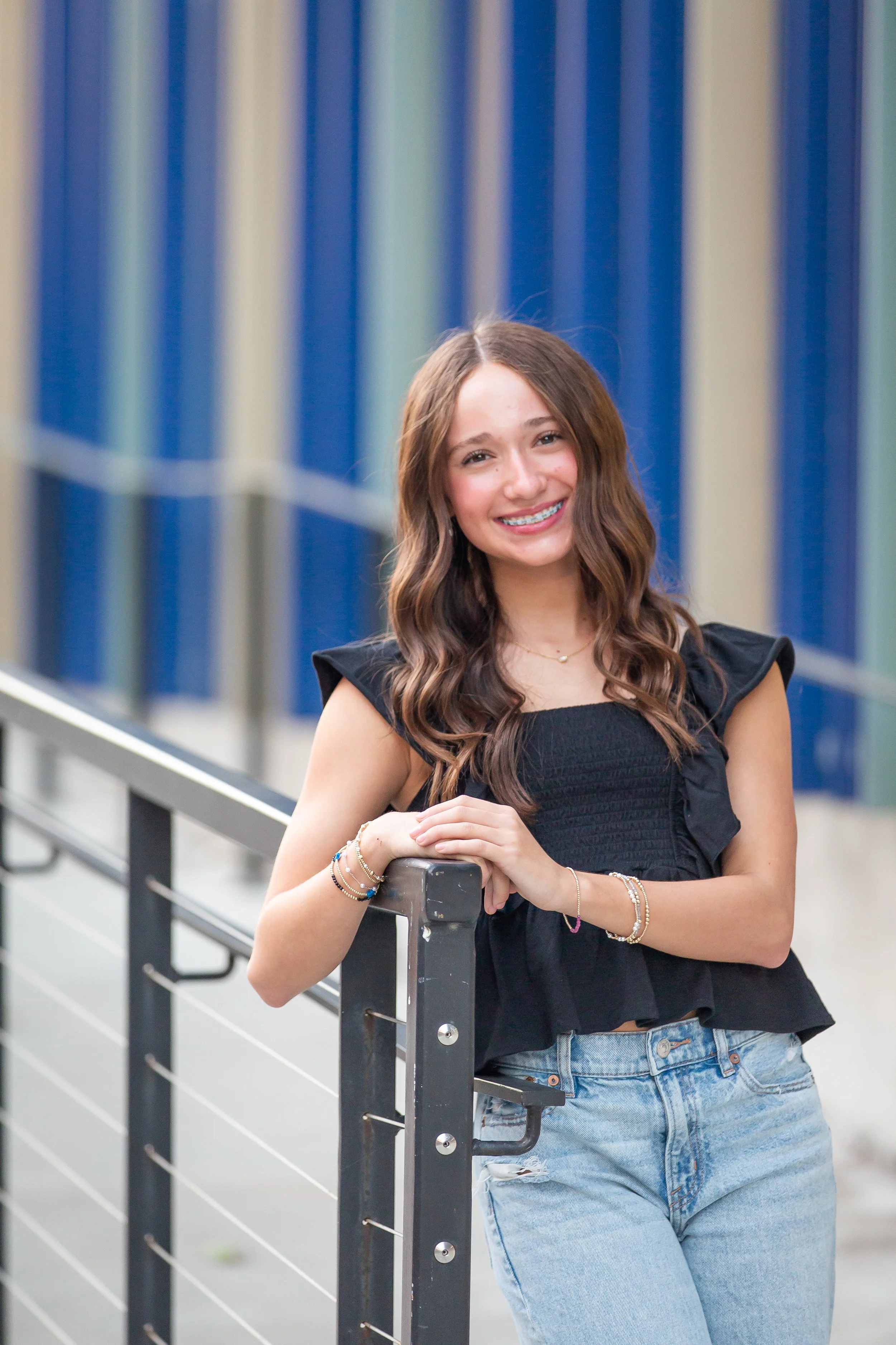 Young girl in white dress smiling on stairs, outdoor portrait