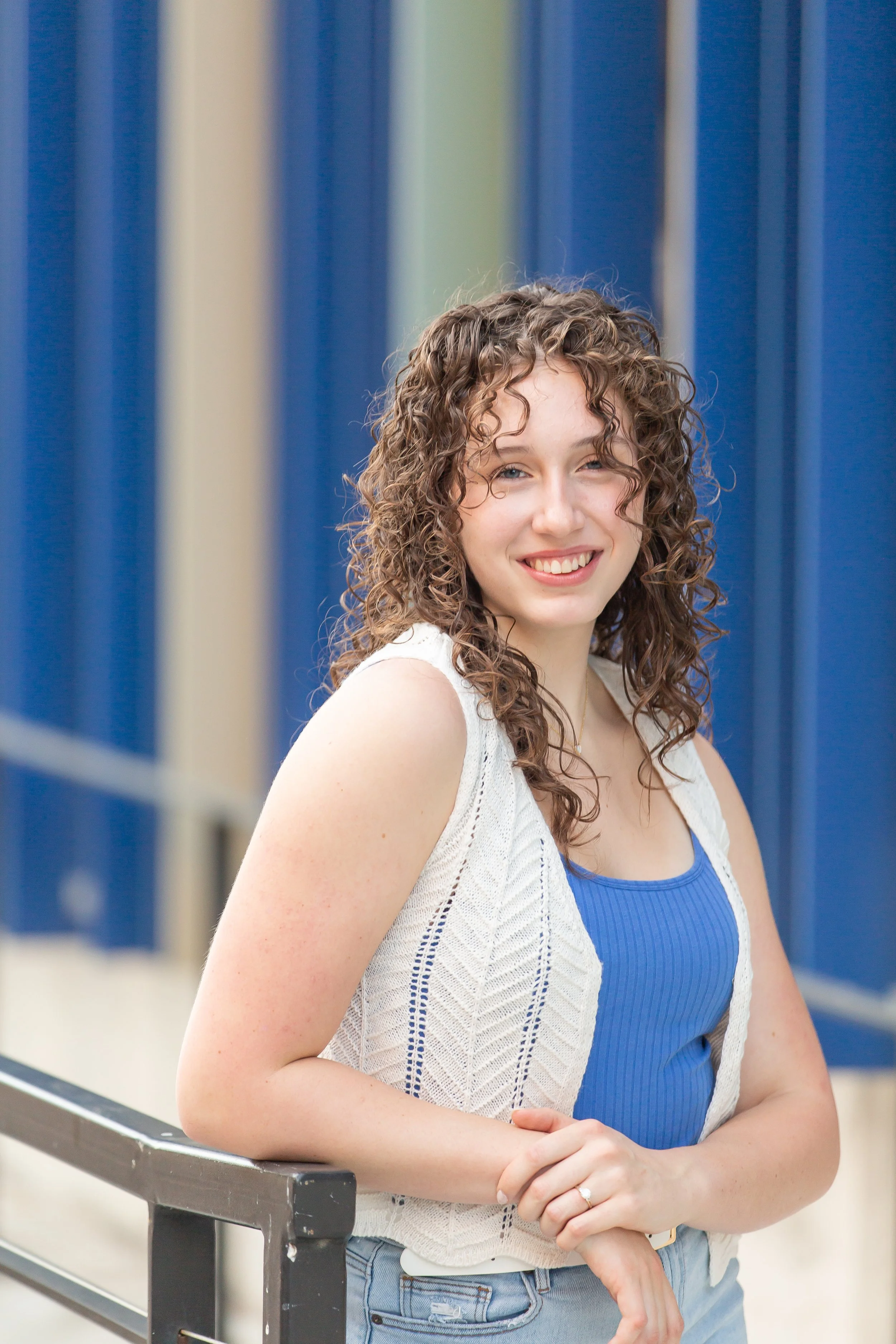 Young girl with braces wearing a light blue dress, standing on stairs