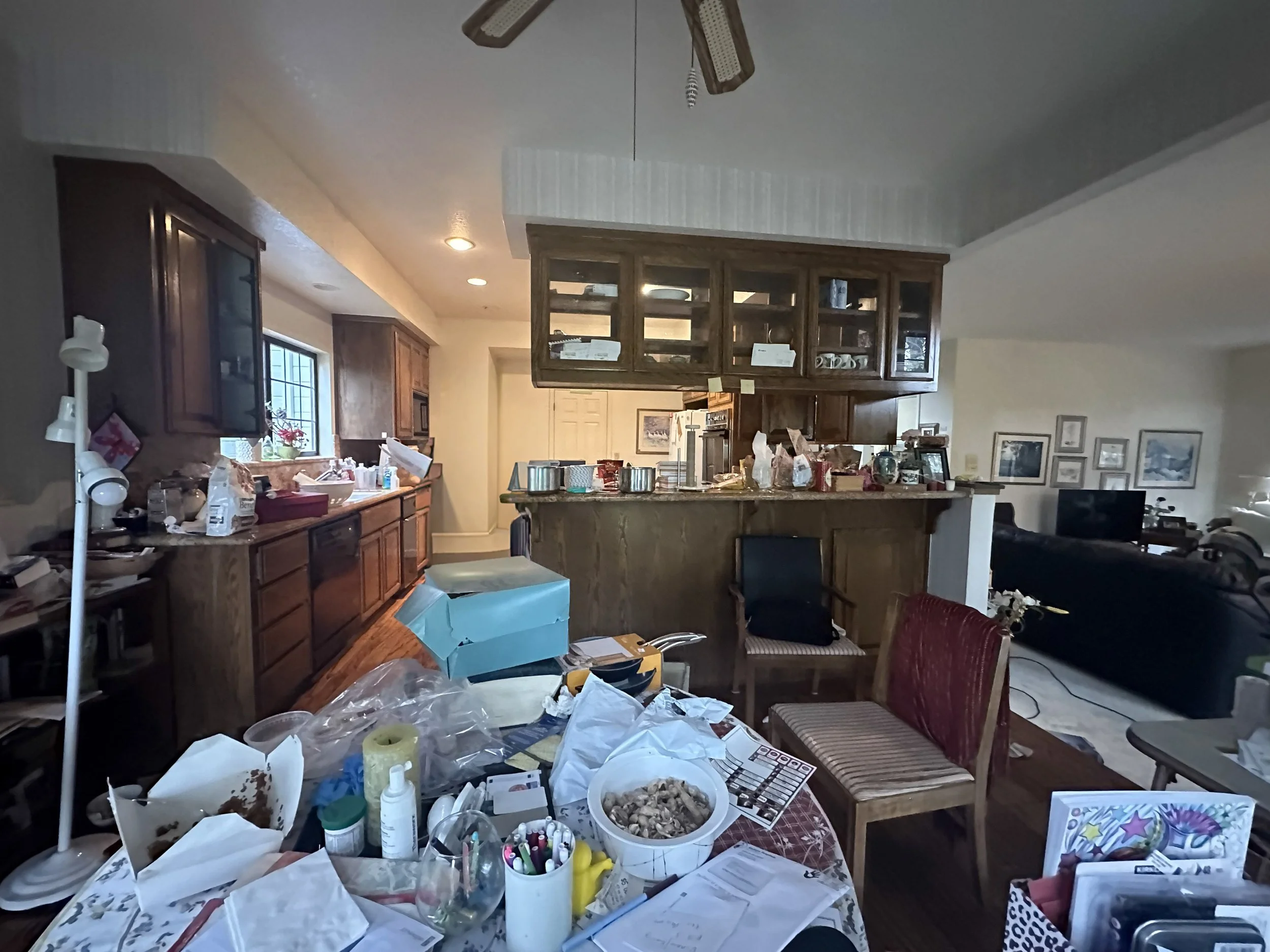 Messy, cluttered Blackhawk kitchen with heavy oak cabinetry and a closed-in layout. Before transformative remodel.