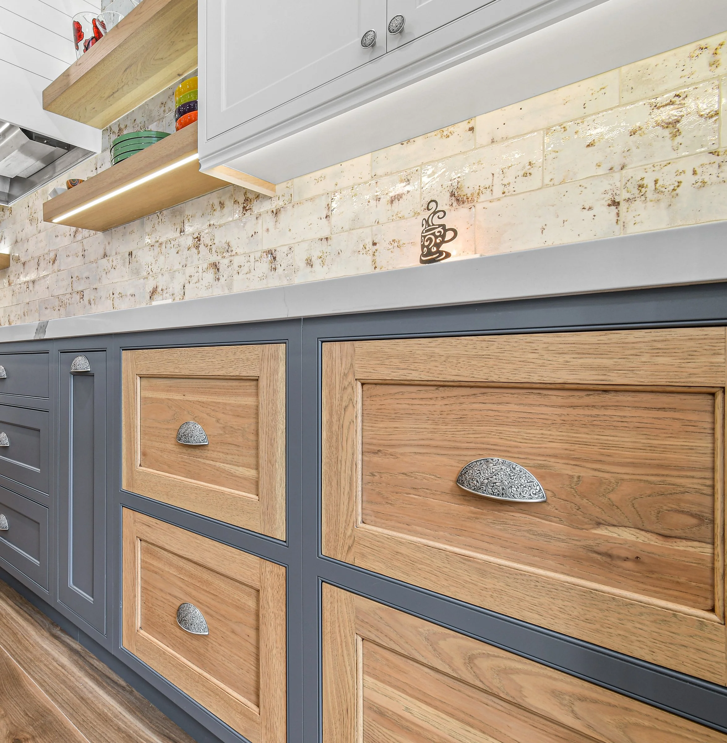 Monday Morning Cabinet Company - Example of Inset Cabinetry from Crystal Cabinets. Close-up of kitchen cabinets with a mix of wood and painted blue finishes.