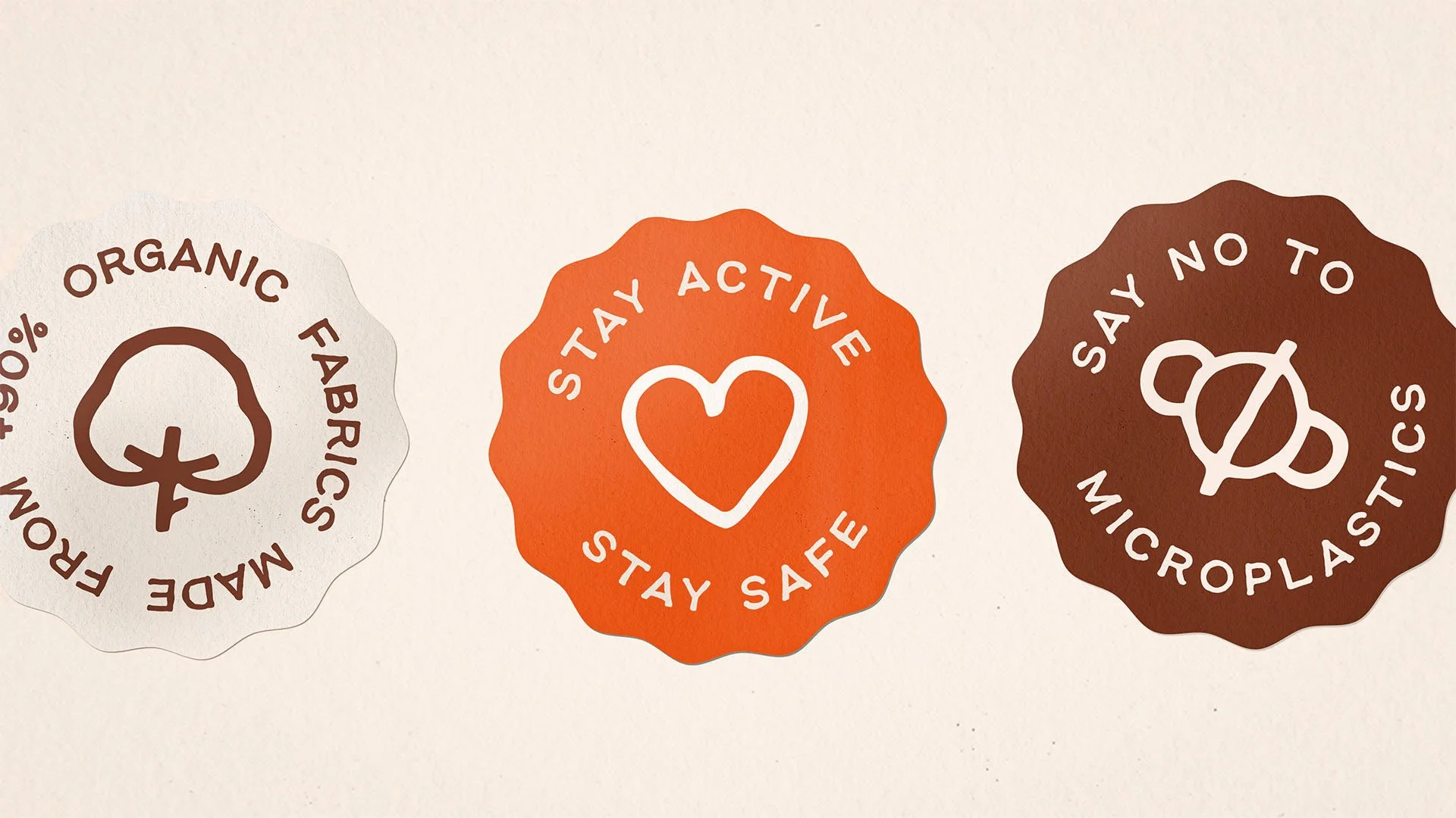 Three circular badges with eco-friendly messages. The first badge has a cotton plant icon and says 'Organic Fabrics Made From 95% Organic.' The second badge has a heart icon and says 'Stay Active, Stay Safe.' The third badge has a recycling icon and says 'Say No to Microplastics.'