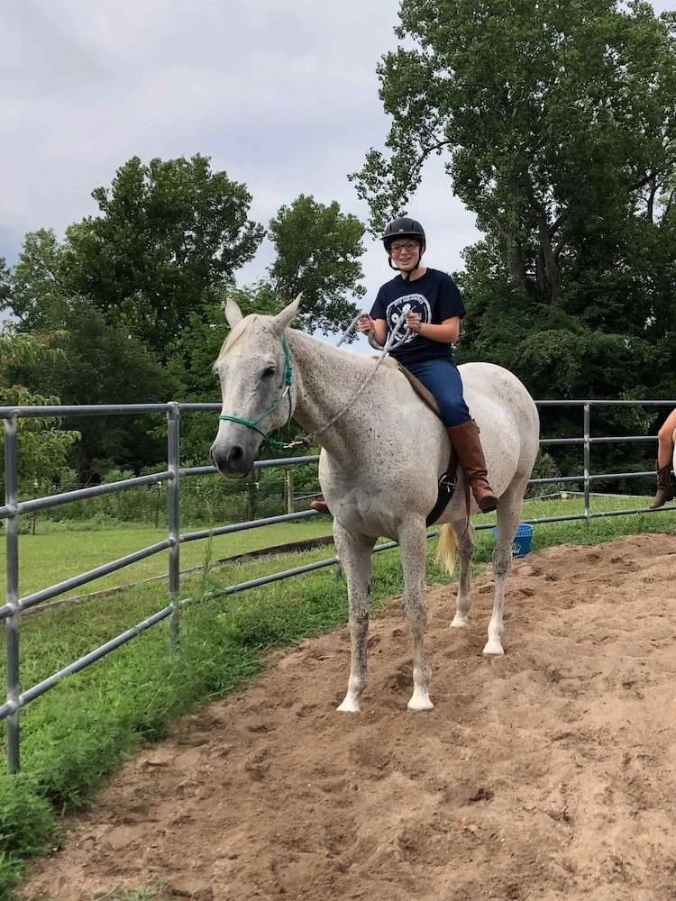 Child participating in a horse riding lesson focused on horsemanship and confidence at Joy Meadows