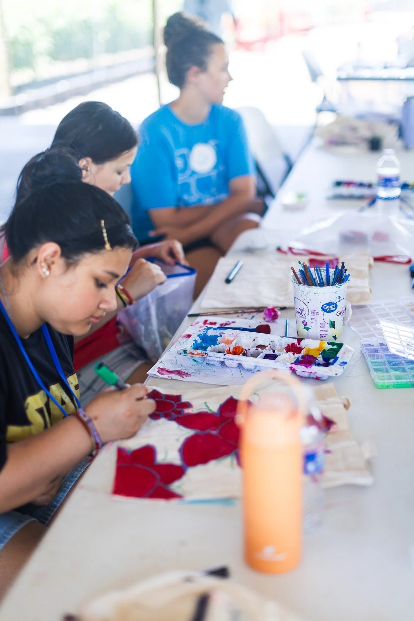 Children paint colorful artwork together at Joy Meadows Art Camp