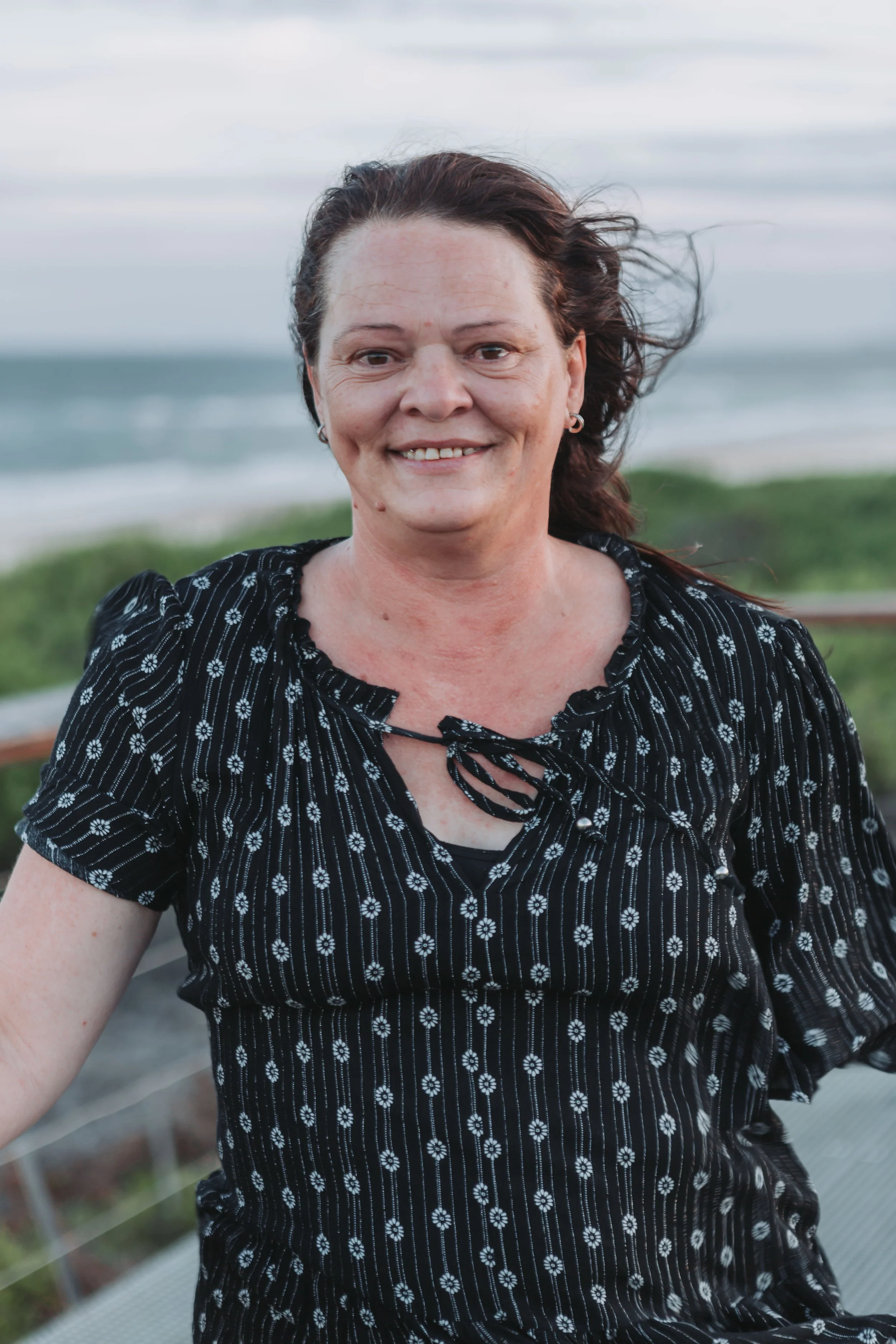 Belinda Mash of Abbotts and Co Lawyers wearing a blak and white top smiling at the camera whilst at North Beach Mylestom