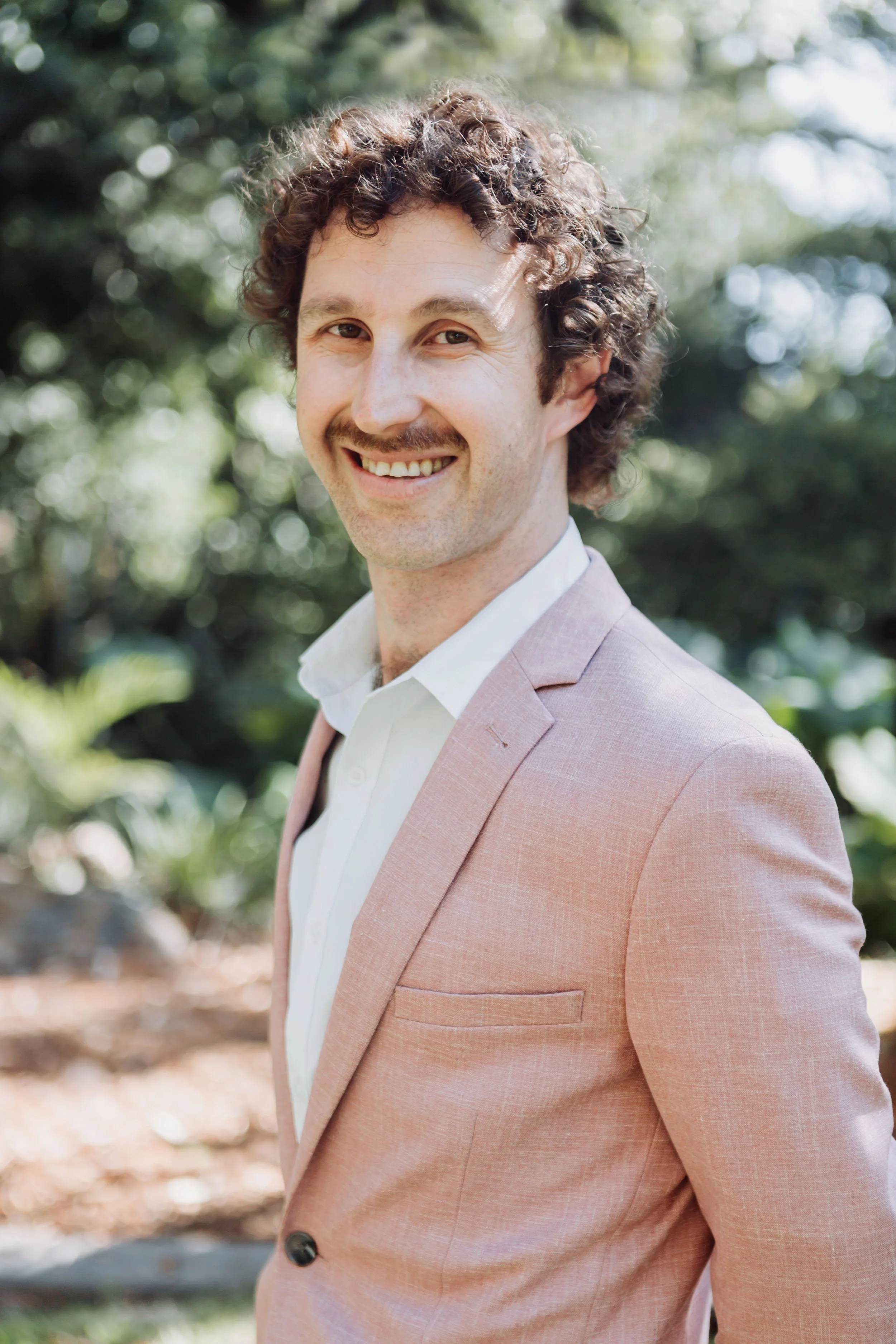 Kieran Abbotts Founder and Principal Solicitor at Abbotts and Co Lawyers wearing a pink suit jacket