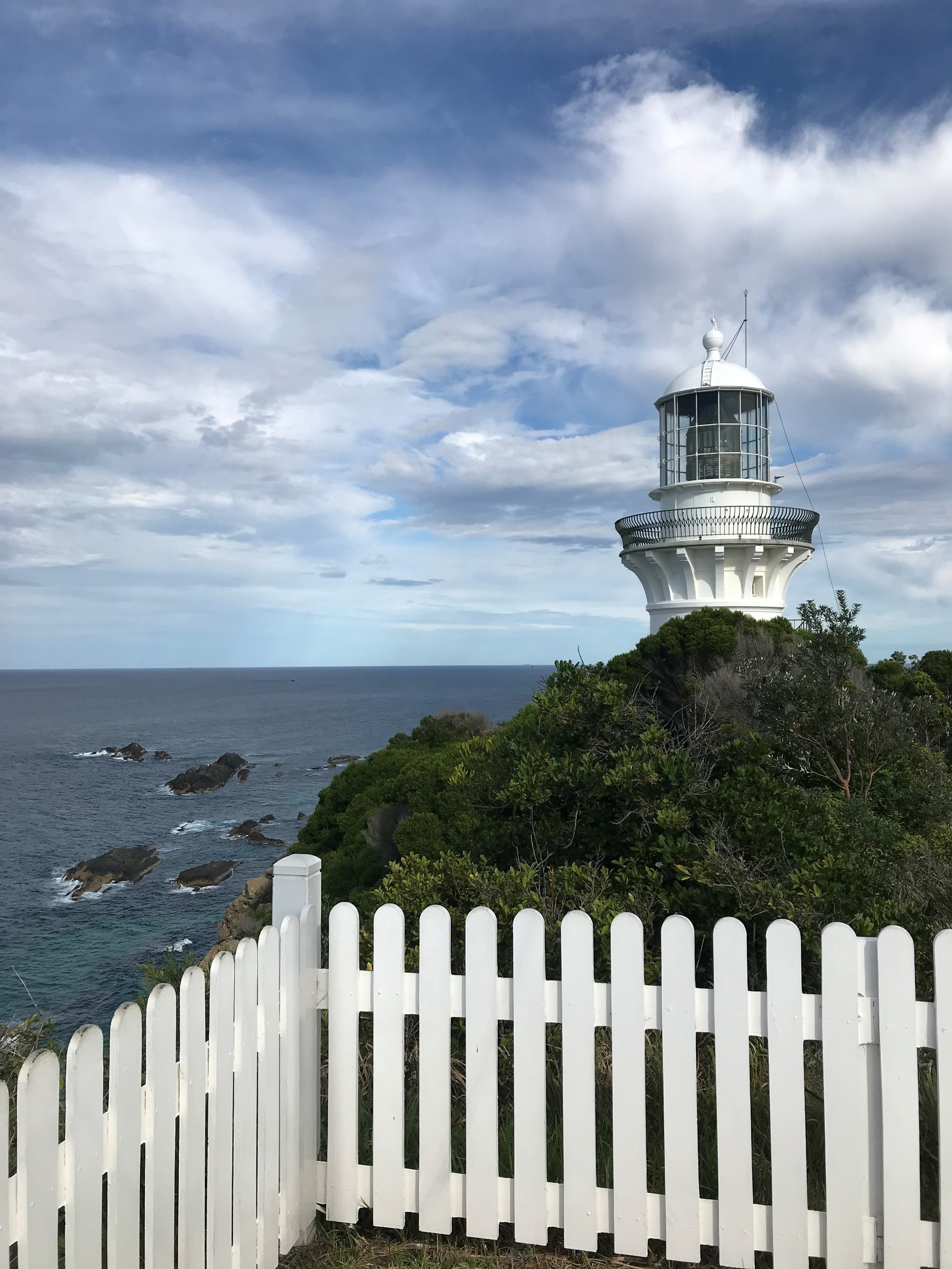 Sugarloaf Point Lighthouse pictured behind a white picket fence at Seal Rocks NSW.