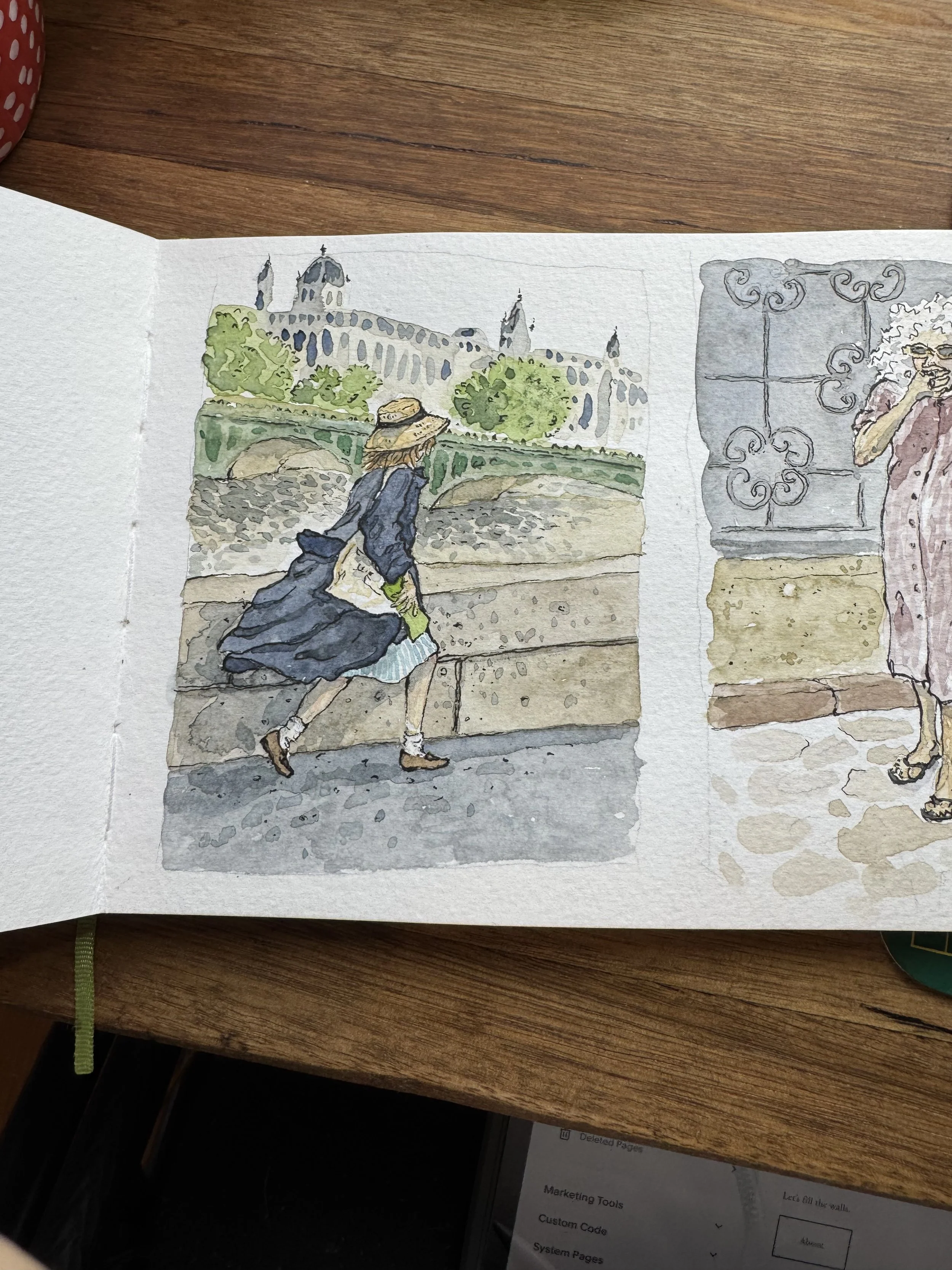 Watercolor illustration of a woman in a long blue coat and straw hat walking along a stone wall near a river, with a large historic building in the background and a woman with white hair and glasses talking on a cell phone inside.