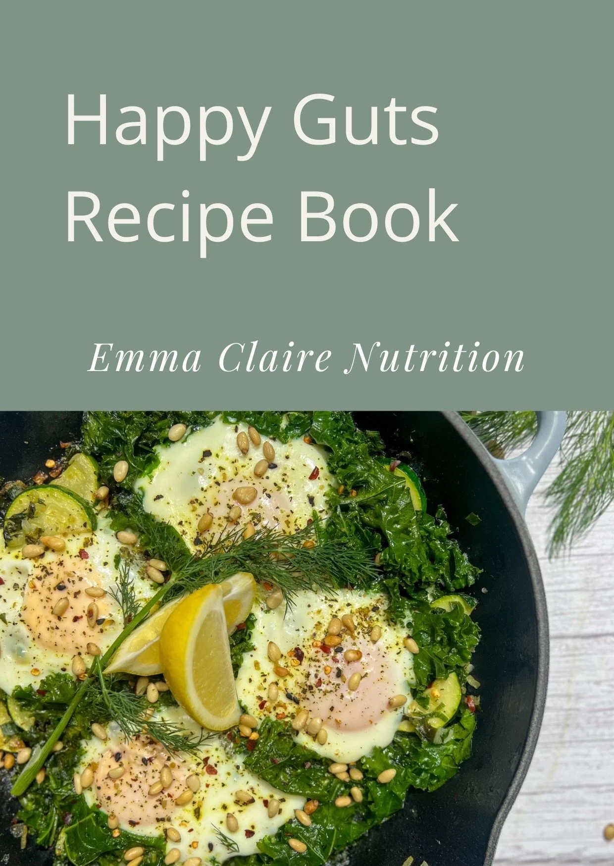 Cover of a recipe book titled 'Happy Guts Recipe Book' by Emma Claire Nutrition, featuring a close-up of a skillet with cooked eggs, fresh green herbs, lemon wedges, and sprinkled seeds.