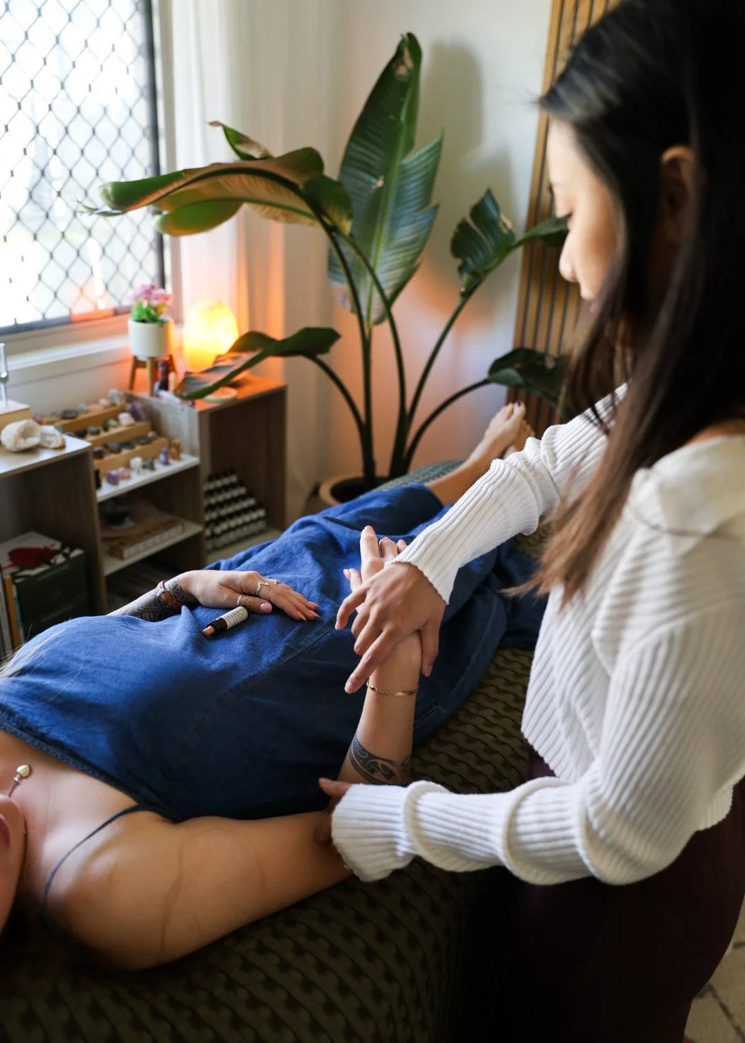 Kineasy Kids Founder, Erika, is muscle monitoring an adult female client with a flower essence on the client's abdomen.