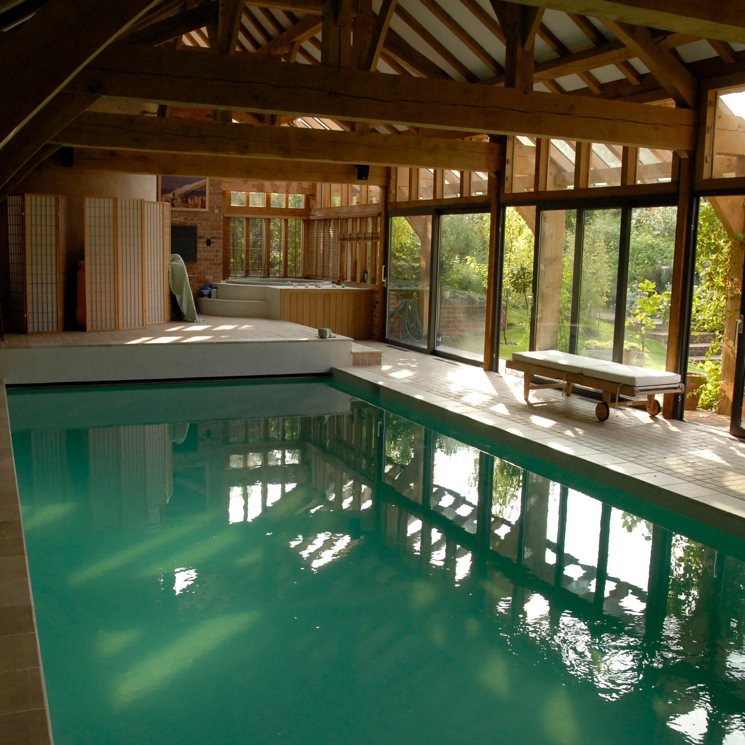 Internal view of barn converted oak framed pool house with aluminium bifold doors.