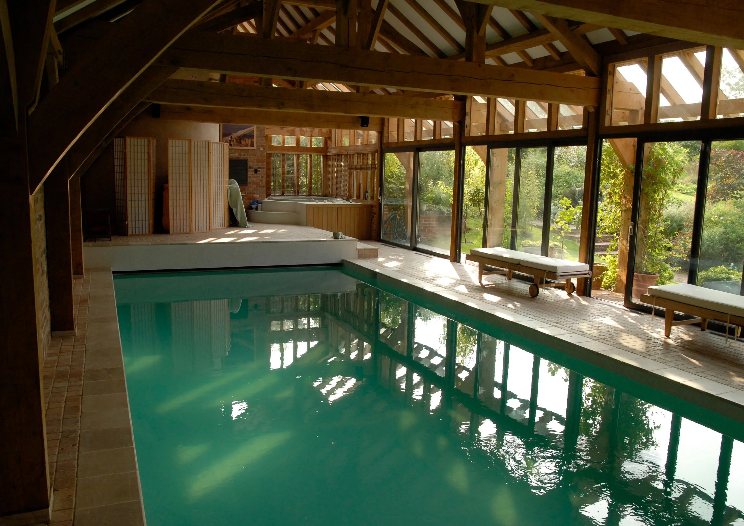 Internal view of barn converted oak framed pool house with aluminium bifold doors.