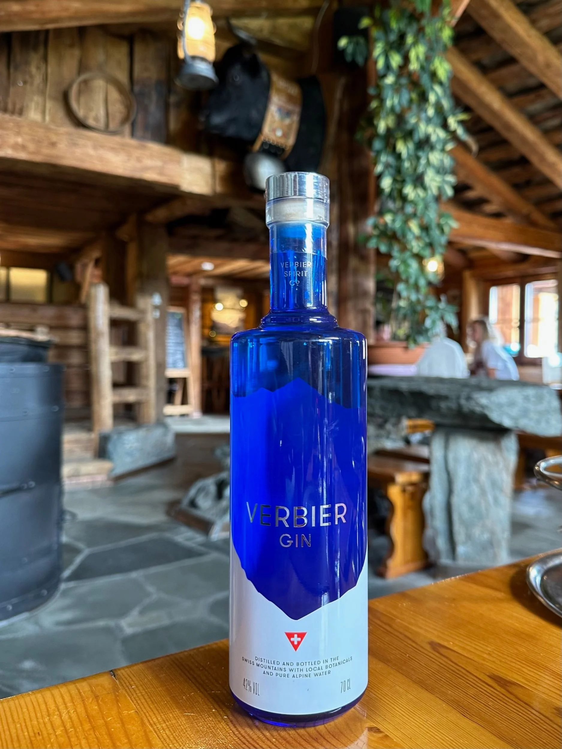 Bottle of VERBIER GIN displayed inside a traditional alpine chalet, reflecting Swiss mountain craftsmanship and lifestyle.