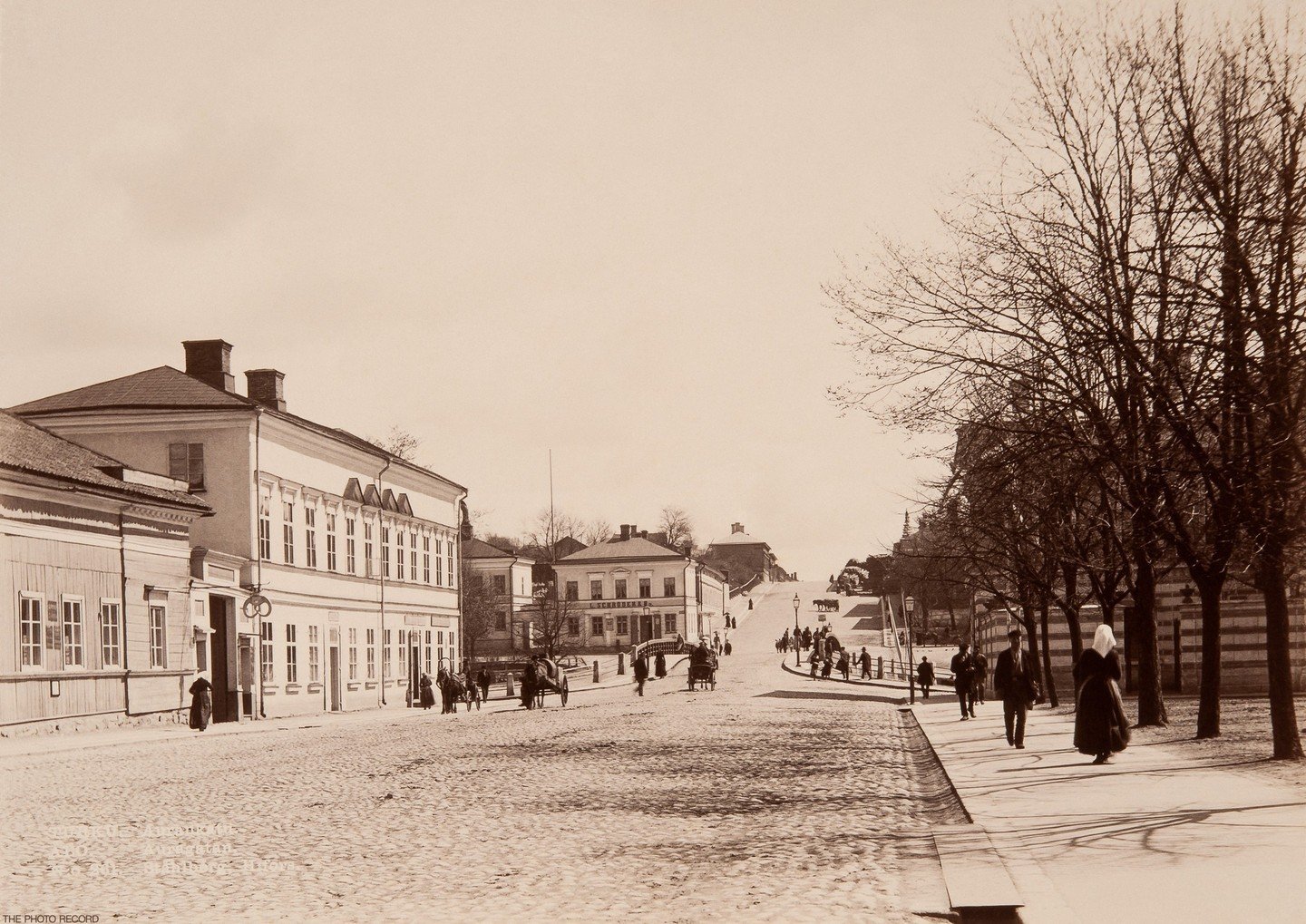 In the 1890s, Aurakatu in Turku was a bustling street characterized by a mix of residential and commercial buildings, reflecting the city's status as an important cultural and commercial center. Lined with shops, cafes, and businesses, the street was