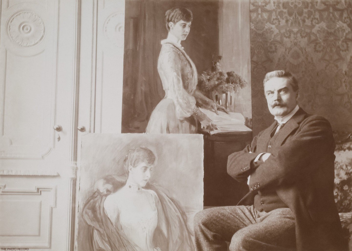 A striking image of Albert Edelfelt, renowned Finnish artist, seated next to his completed portrait of Princess Charlotte of Saxe-Meiningen. Edelfelt emerged as a leading figure in Finnish art during the late 19th century and significantly contribute