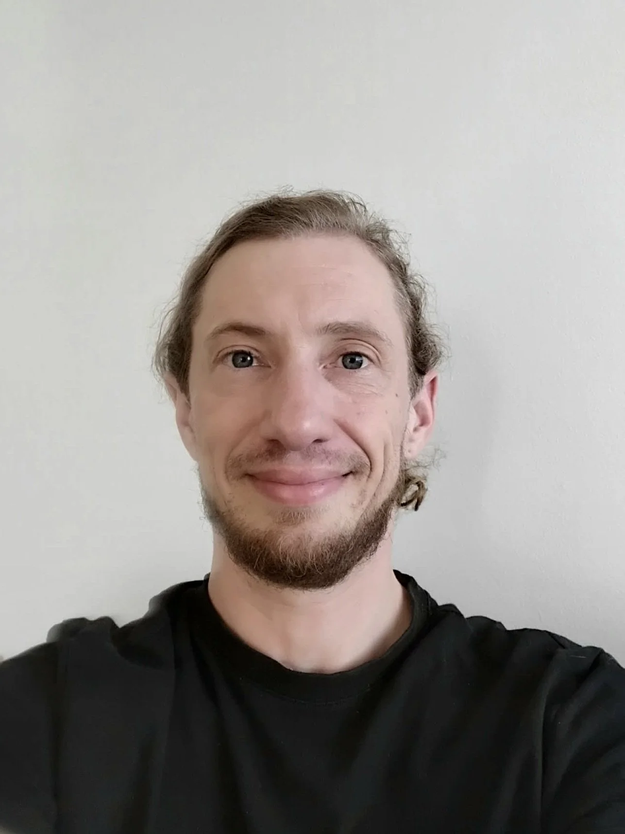 A man is looking towards the camera smiling.