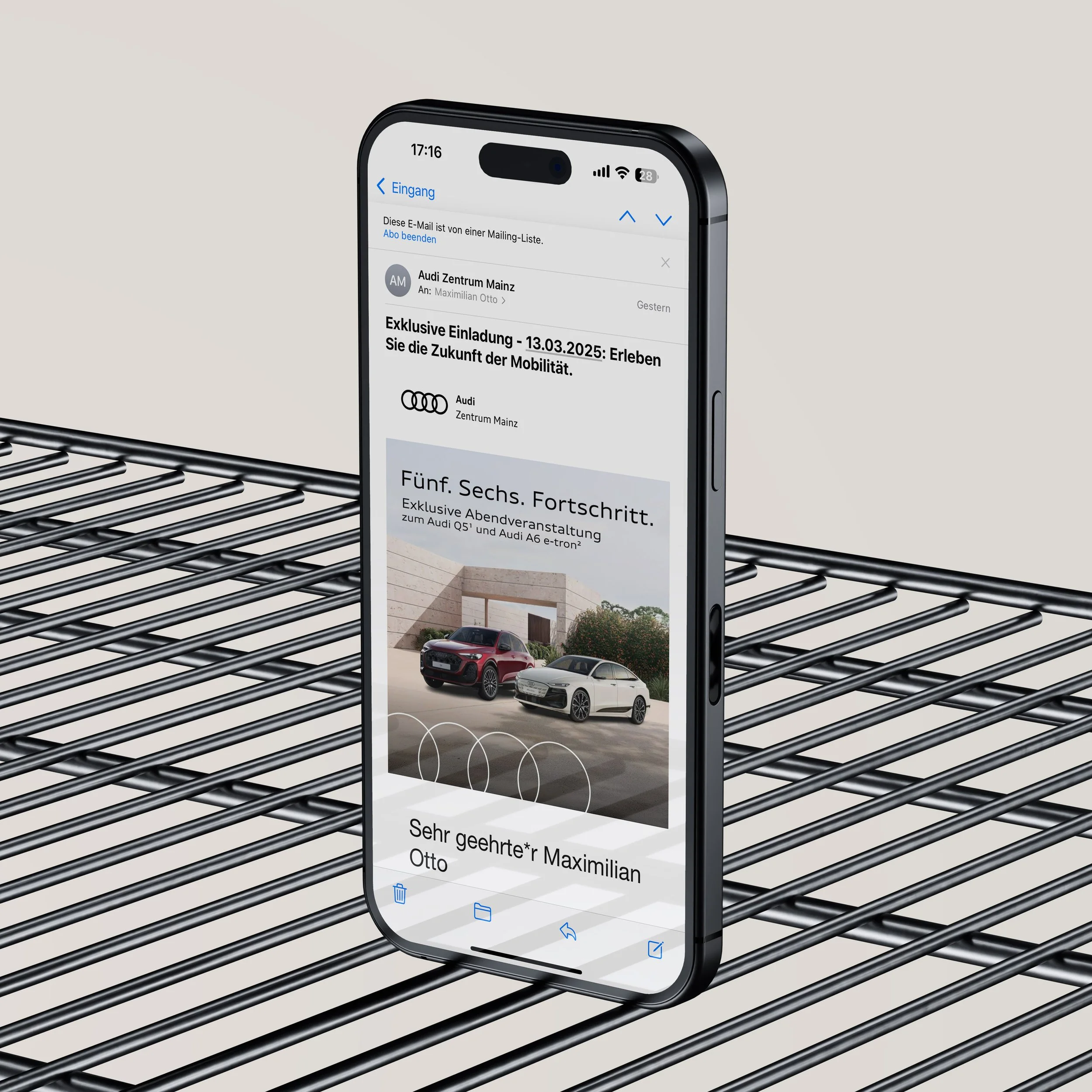 Smartphone mit einer E-Mail im Posteingang, der an Maxilian Otto von Audi Mainz gerichtet ist, mit einem Bild von zwei Audi-Fahrzeugen und einem Text über Fortschritte in der Mobilität.