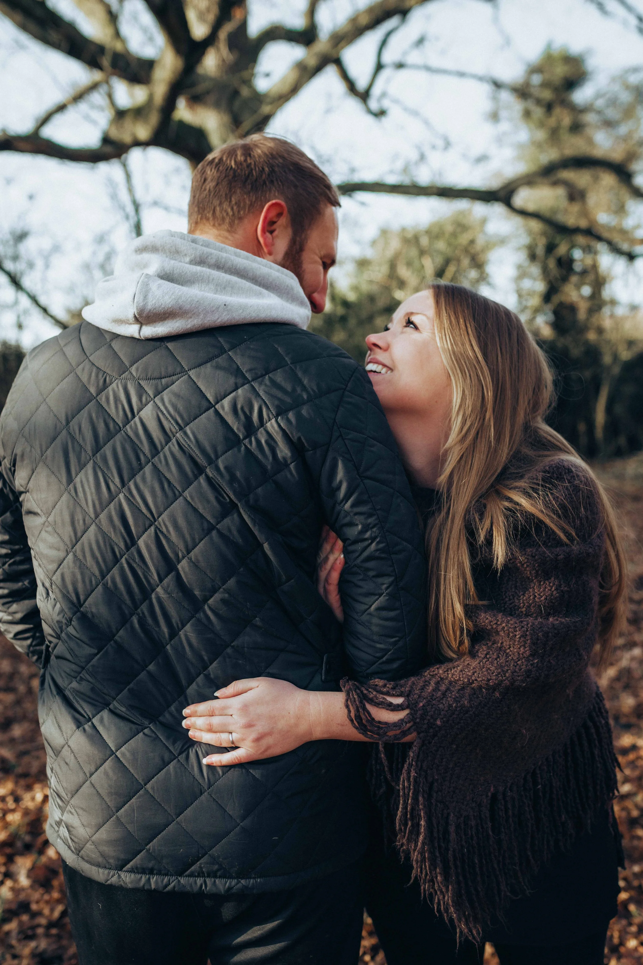 A couple playfully embracing and smiling at each other during a pre-wedding session near Colchester