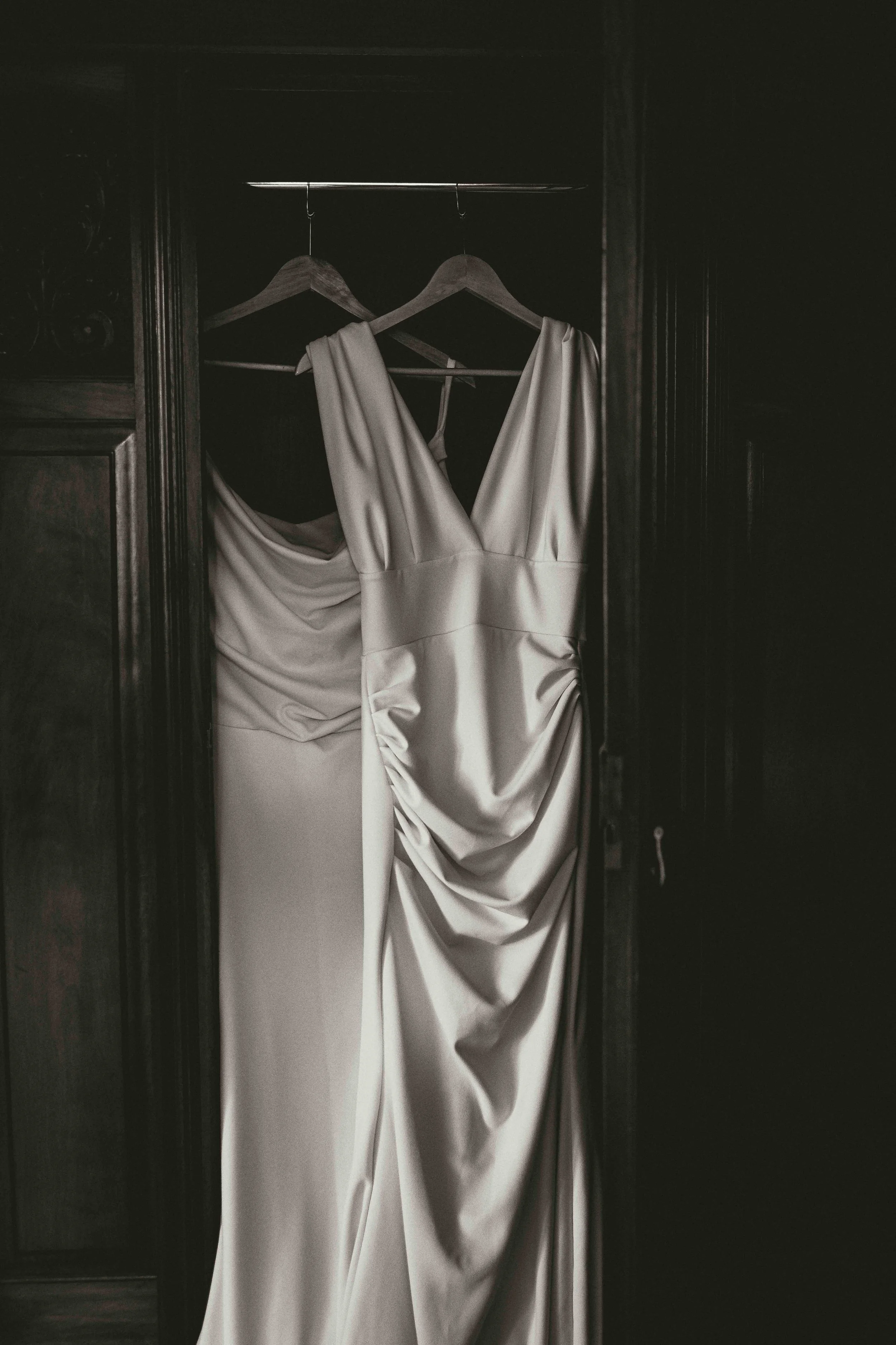 wedding dress hanging in a slightly opened wardrobe in the bridal suite of Hockwold Hall in Hockwold cum Wilton Norfolk