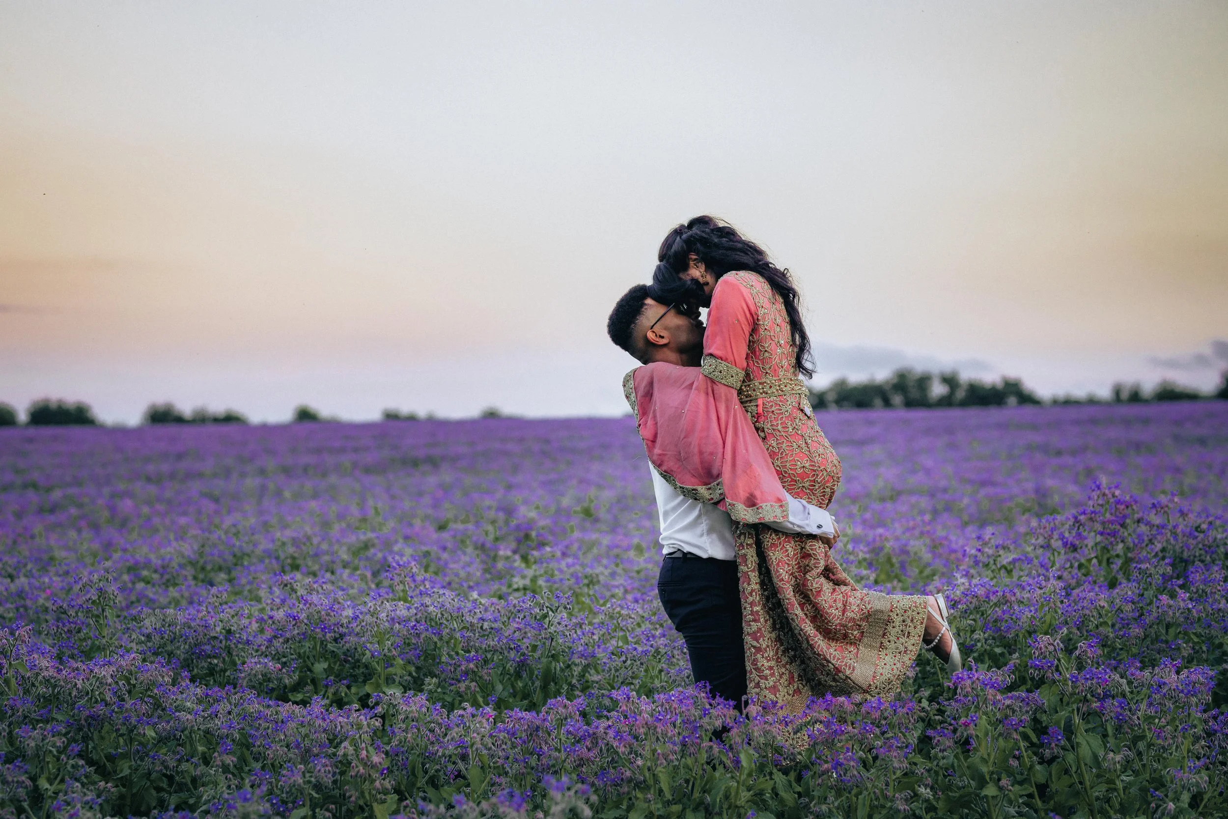 bride and groom sitting in a vintage car after the ceremony and enjoying a glass of champagne together laughing, London wedding photographer