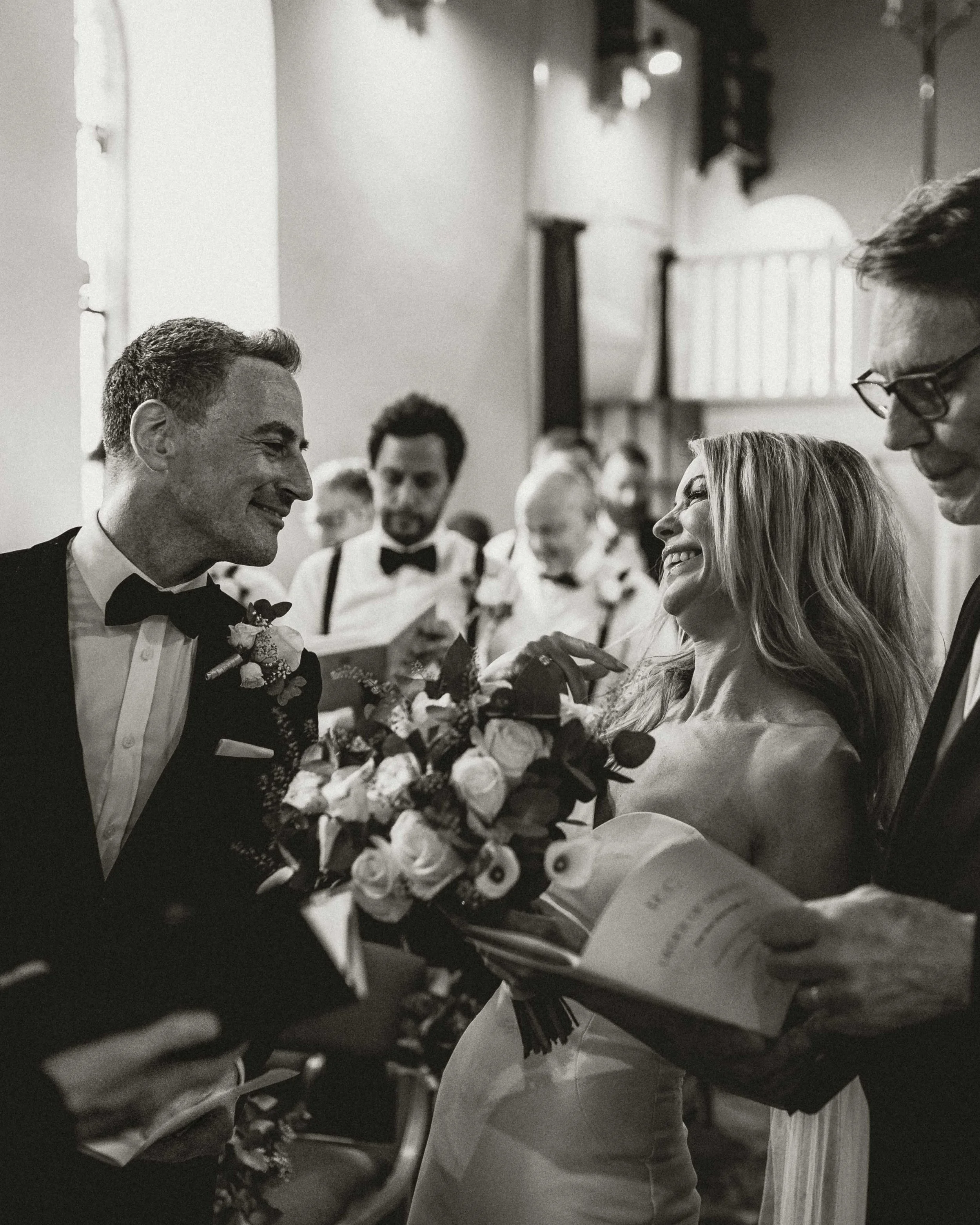 Bride and groom smiling at each other during church ceremony in Norfolk, London wedding photographer, documentary wedding photographer