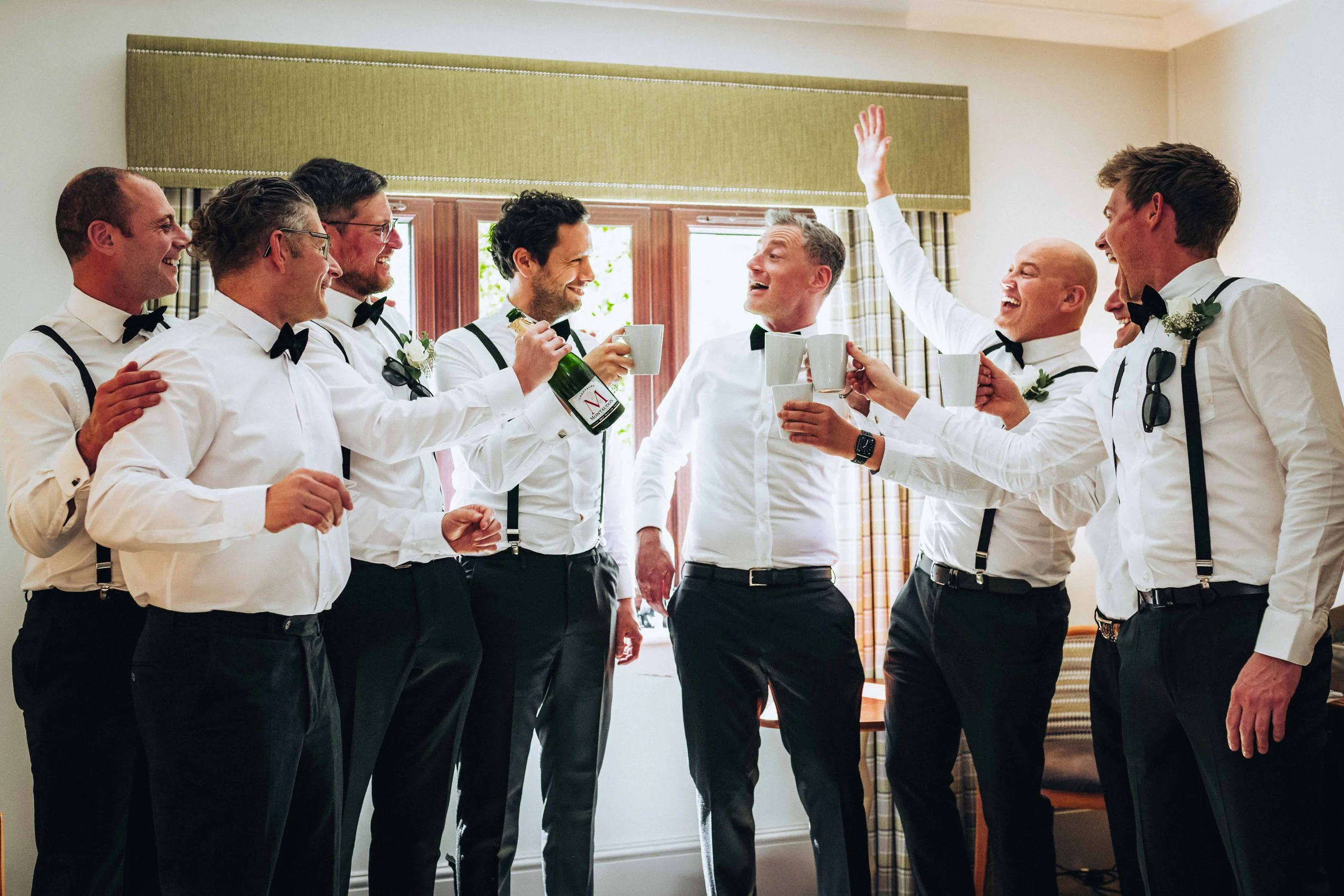 Groom and groomsmen are cheering and laughing before the ceremony at Dunston Hall near Norwich