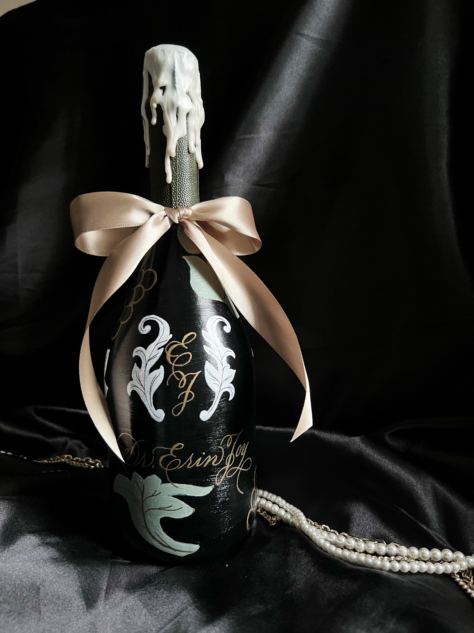 Prosecco bottle with hand painted black background, sage green and white acanthus leaves, gold calligraphy monogram and name