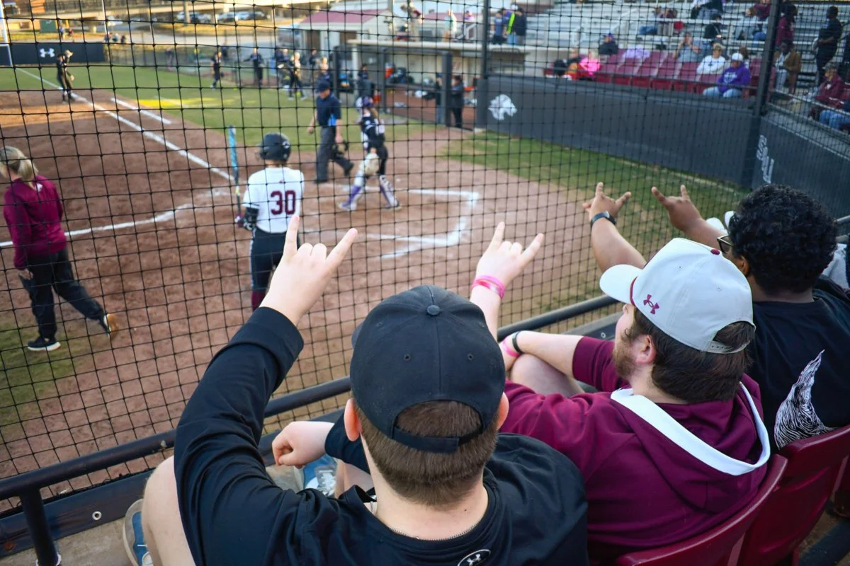 Dawg Pound president Corey Crombar and Vice President of Game Day Operations Jacob Bryant make a dog with their fingers during an SIU Softball game Feb. 28, 2025 at Charlotte West Stadium in Carbondale, Illinois.