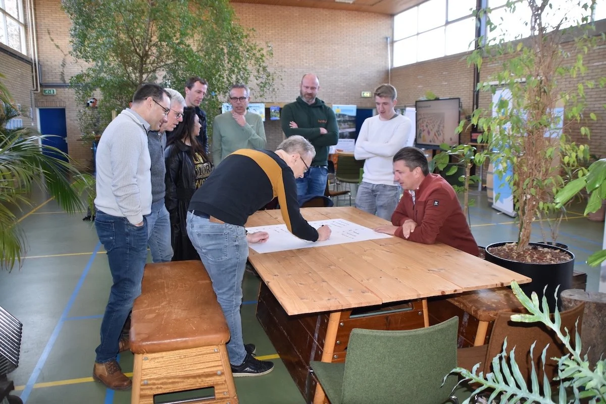 Team Kyndryl tekent een opdracht op tafel