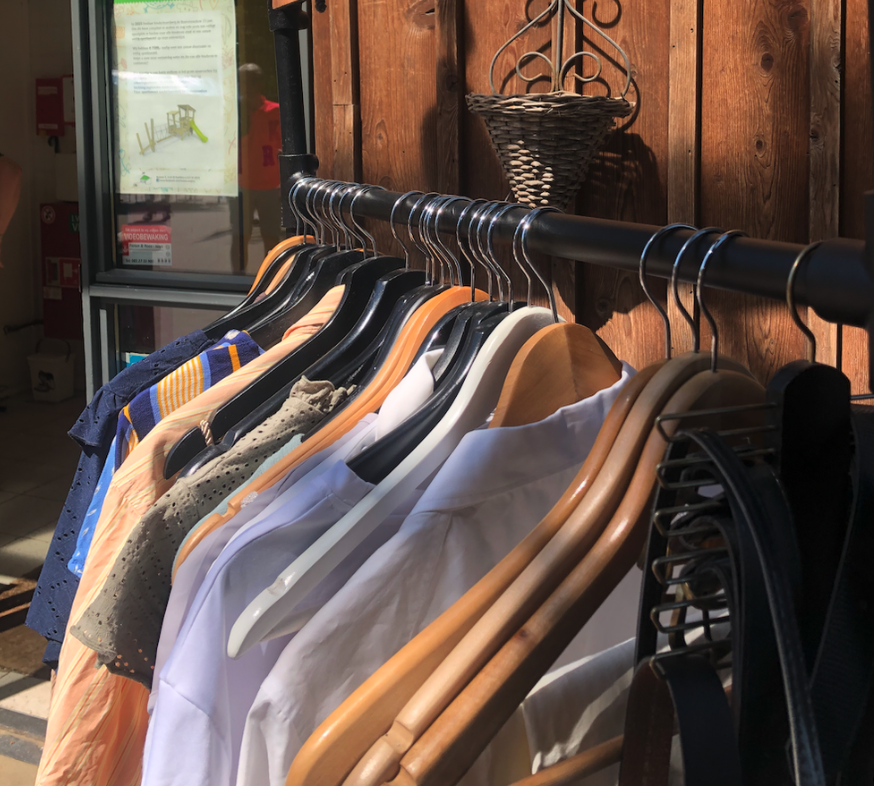 Close-up foto van kledingrek met hangers met kleding eraan